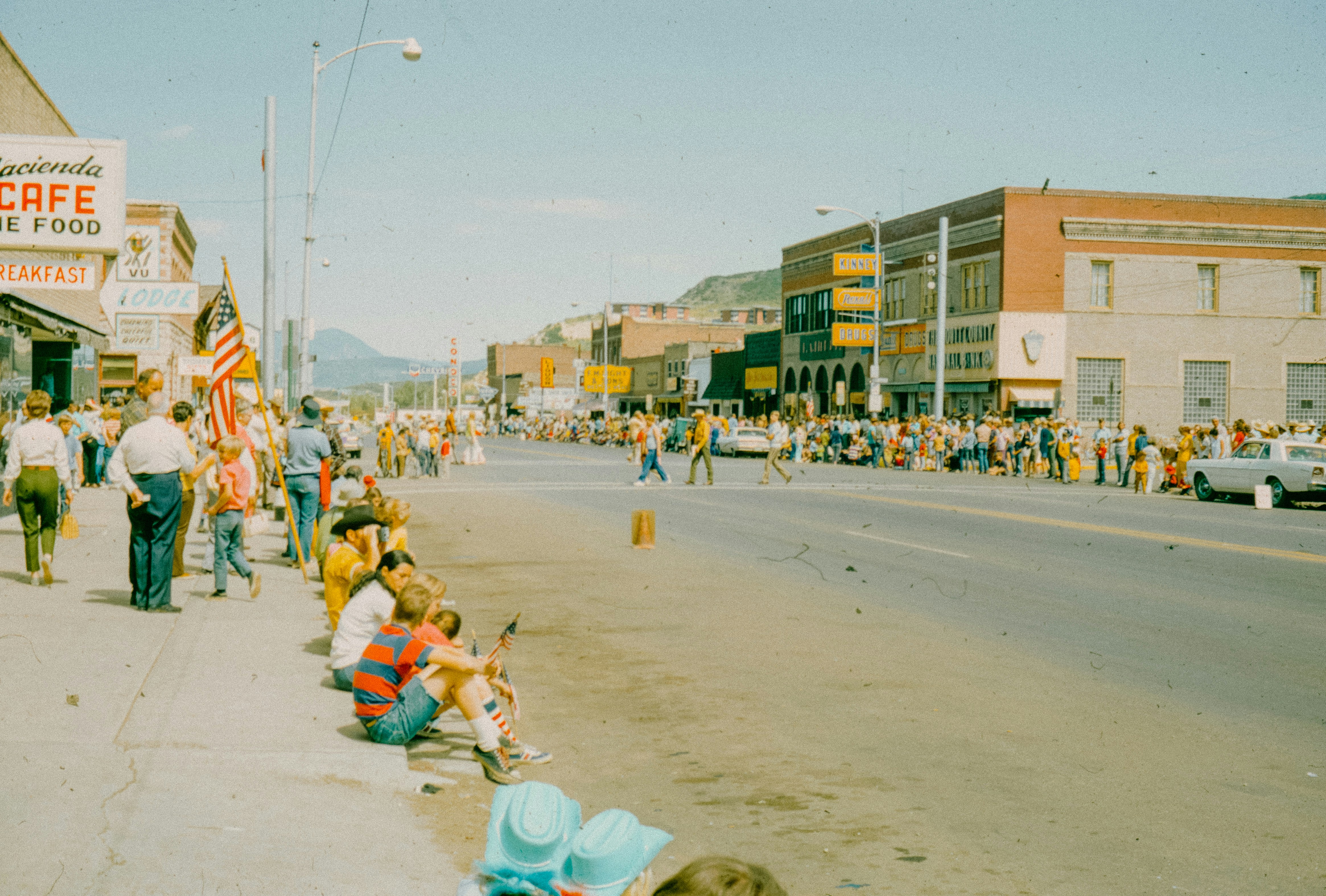 A crowd of people walking down a street next to tall buildings