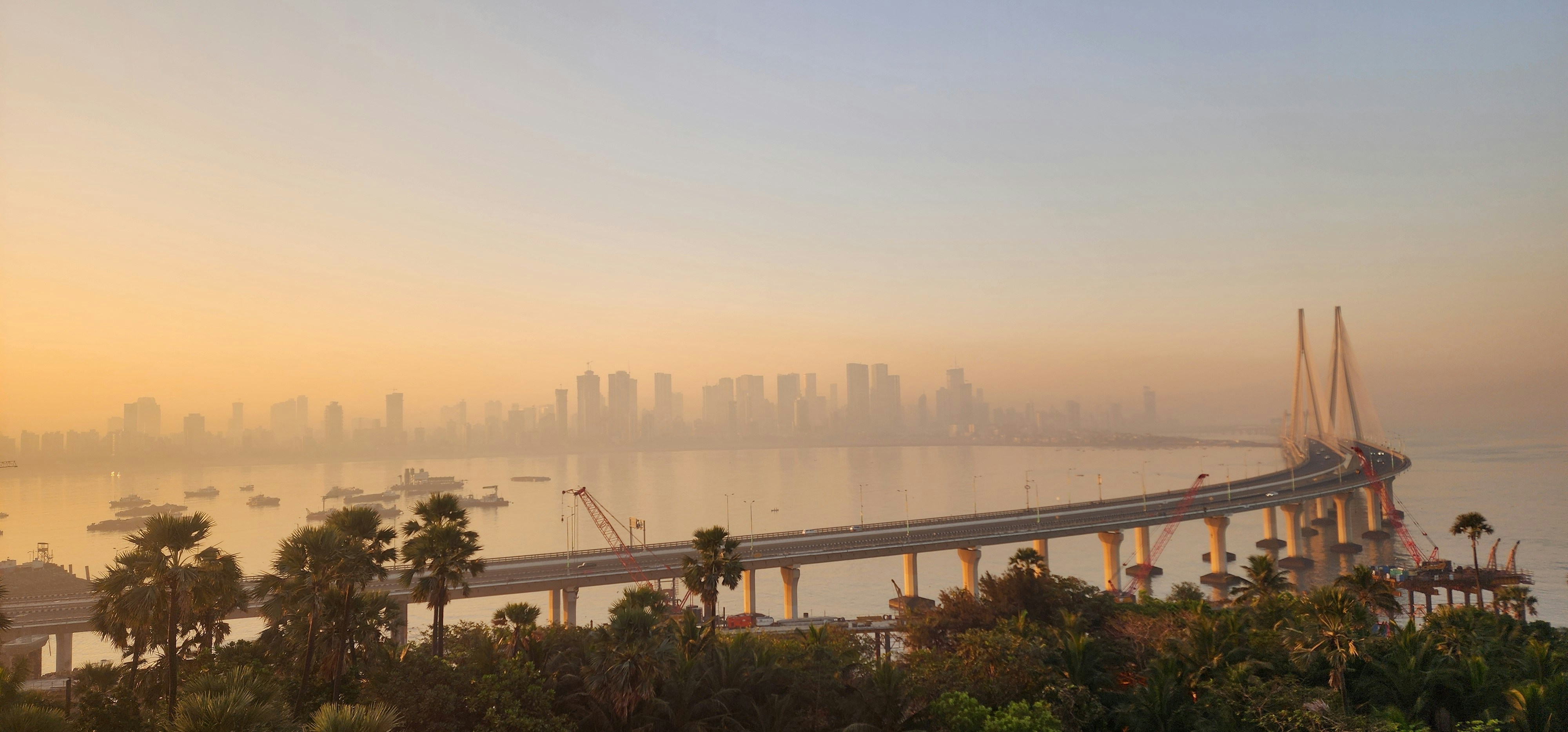 A bridge over a body of water with a city in the background photo ...