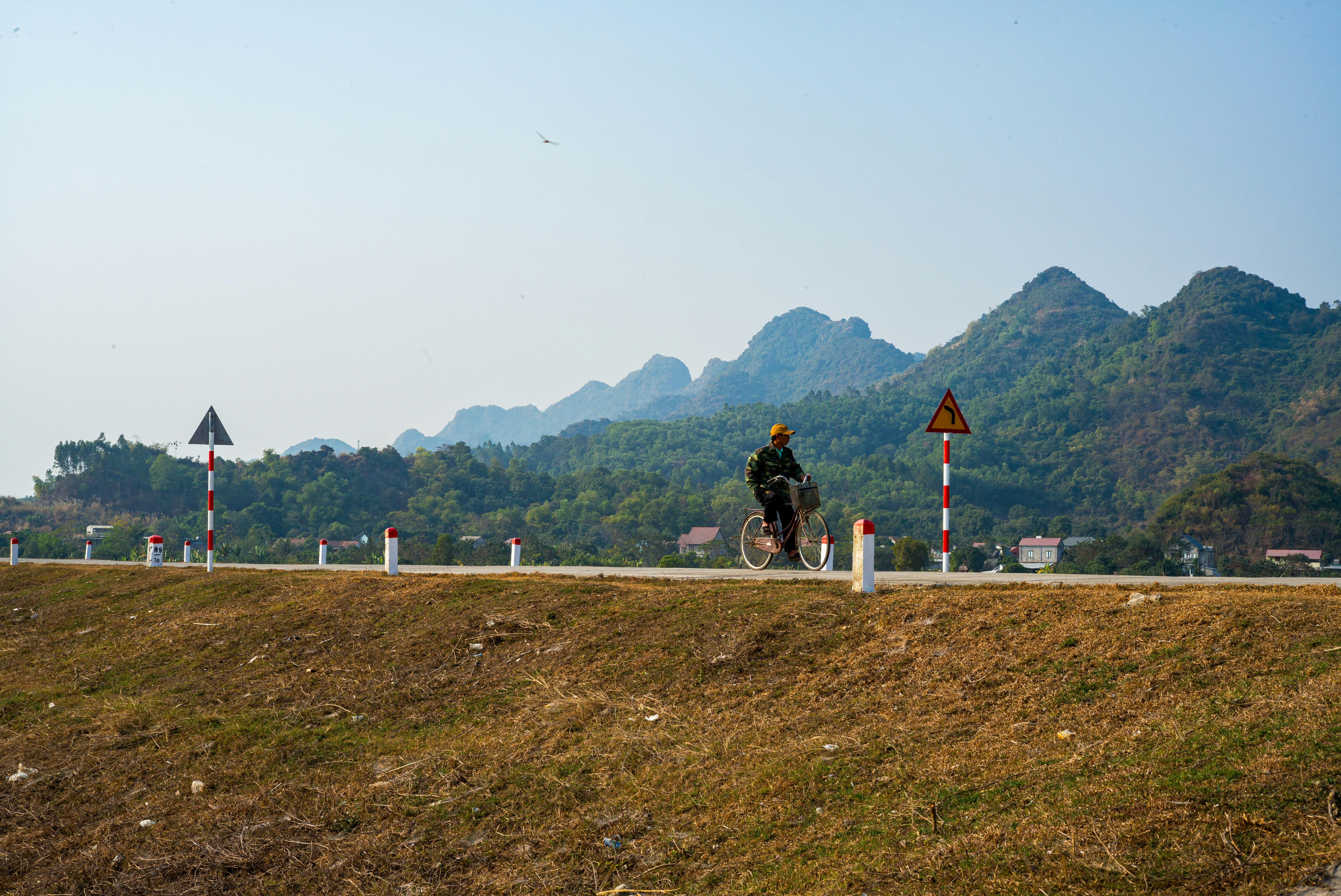 A couple of people riding bikes down a road