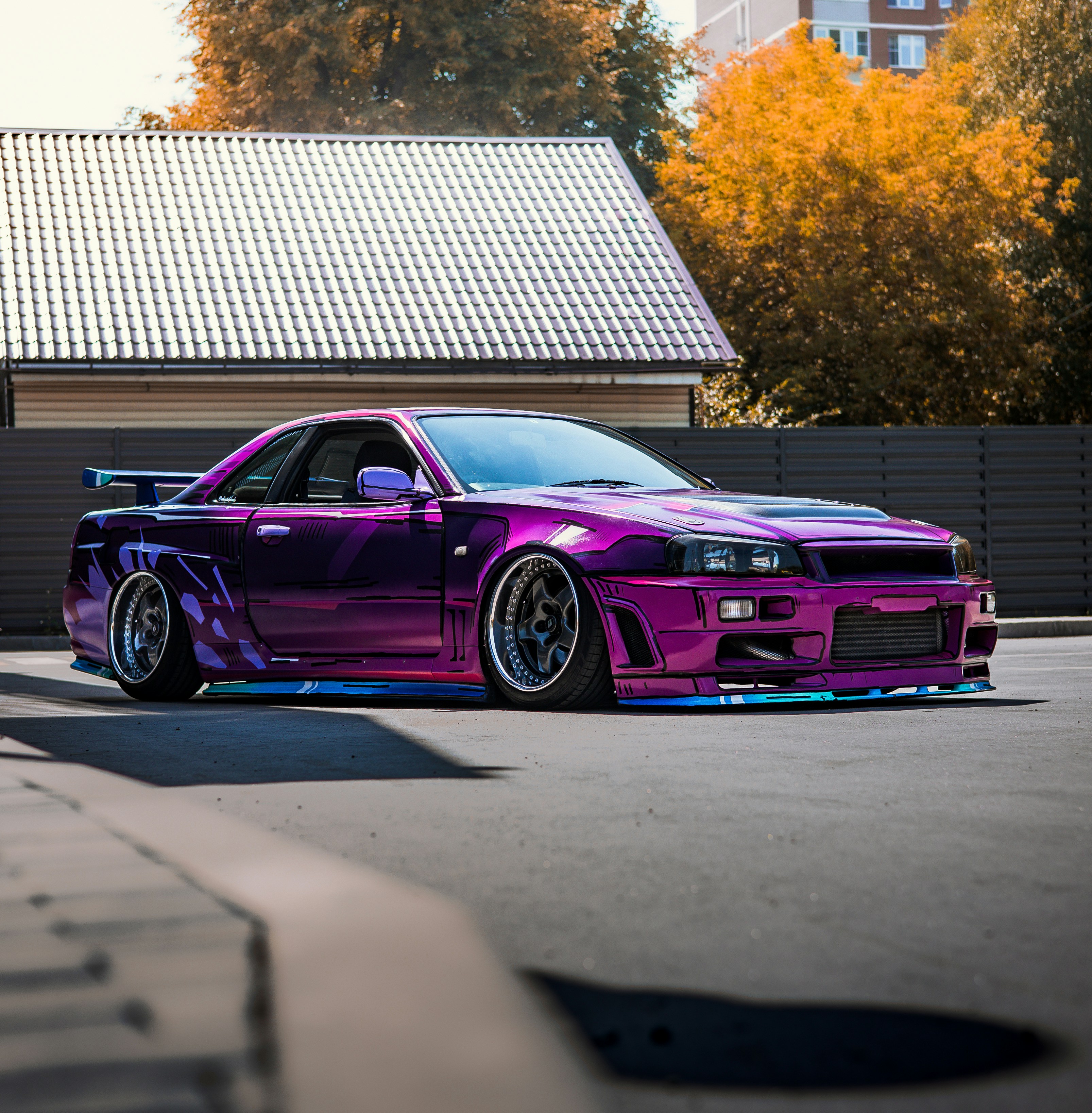 A purple car parked in front of a house