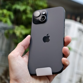 A person holding an iPhone in their hand