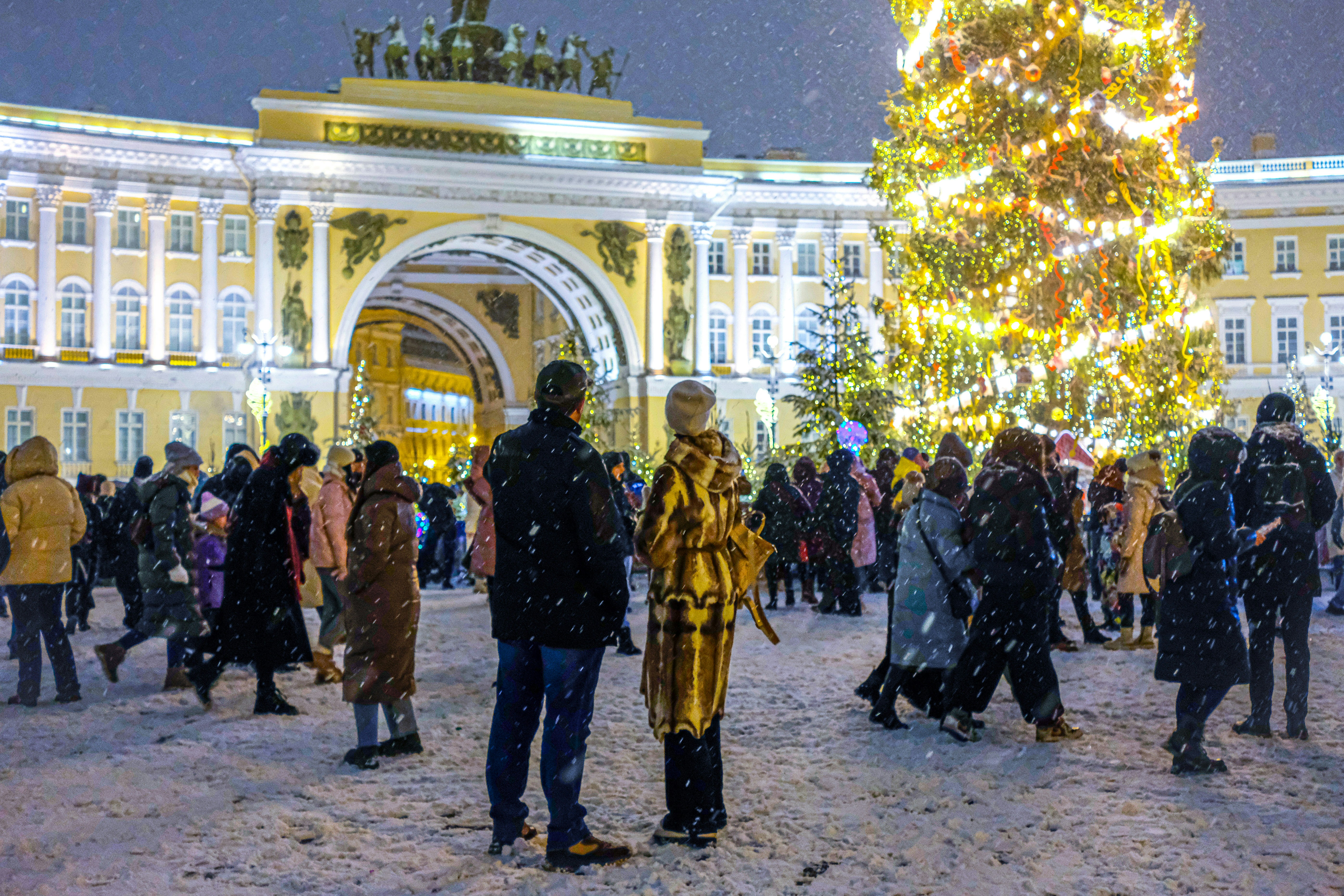 A group of people standing in front of a christmas tree