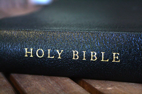 A bible sitting on top of a wooden table