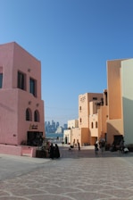 A group of people sitting outside of a pink building
