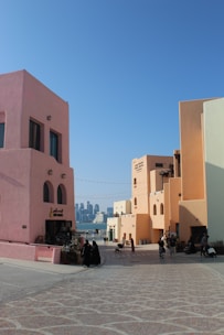 A group of people sitting outside of a pink building