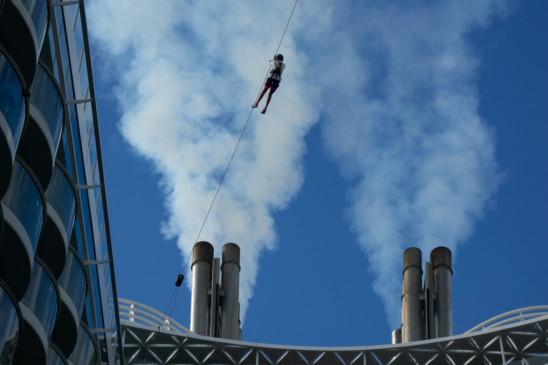 A person on a rope in the air above a building