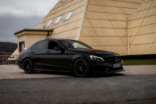 A black car parked in front of a building