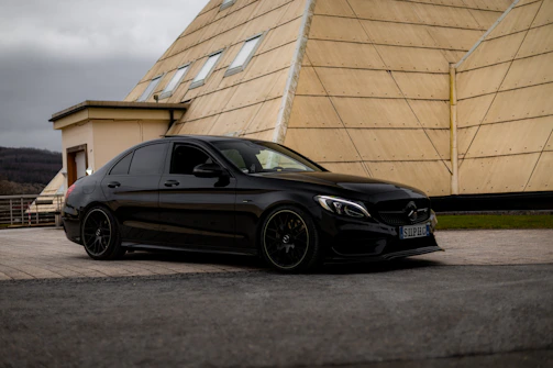 A black car parked in front of a building