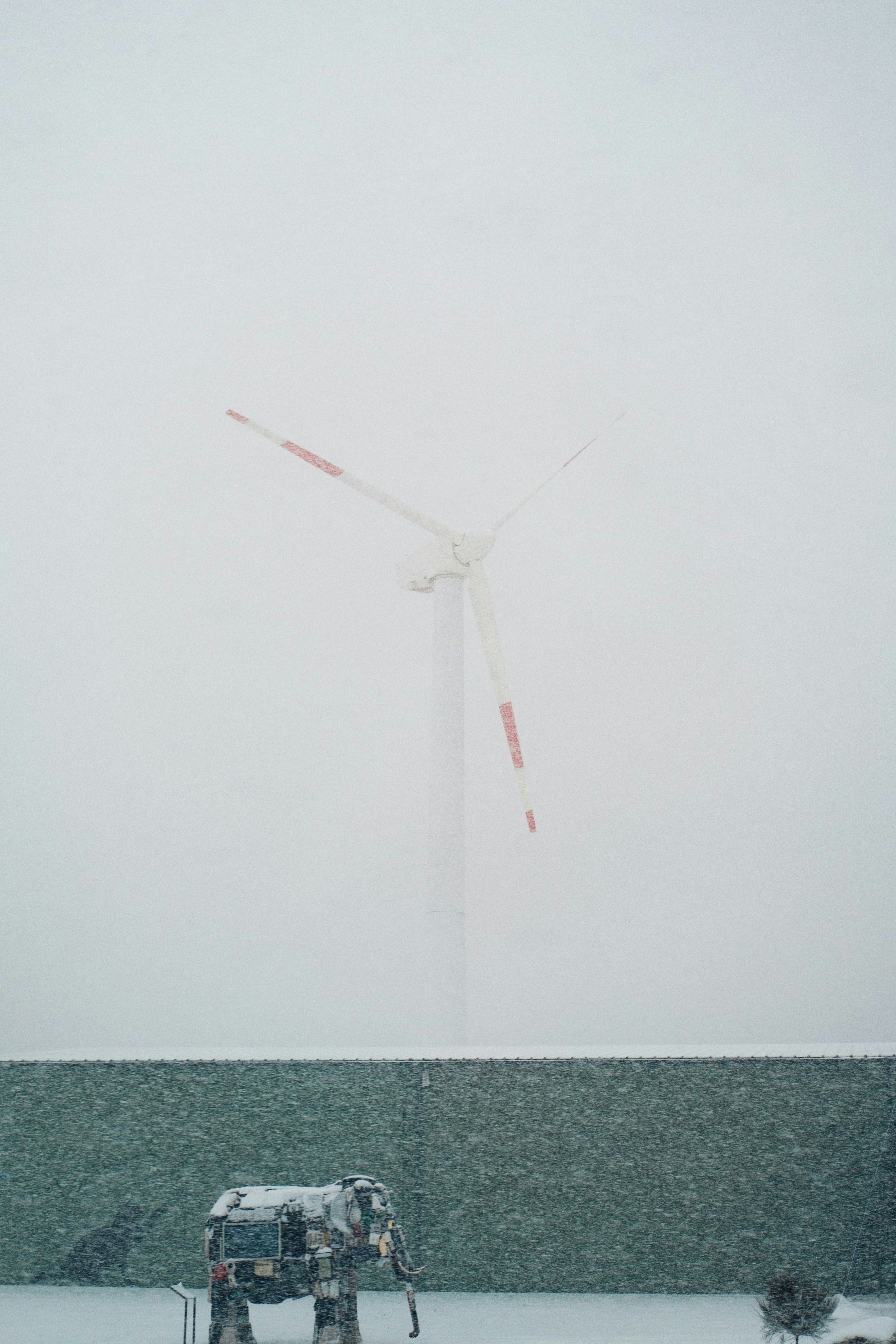 A wind turbine in the middle of a snowy field photo – Free Human Image ...