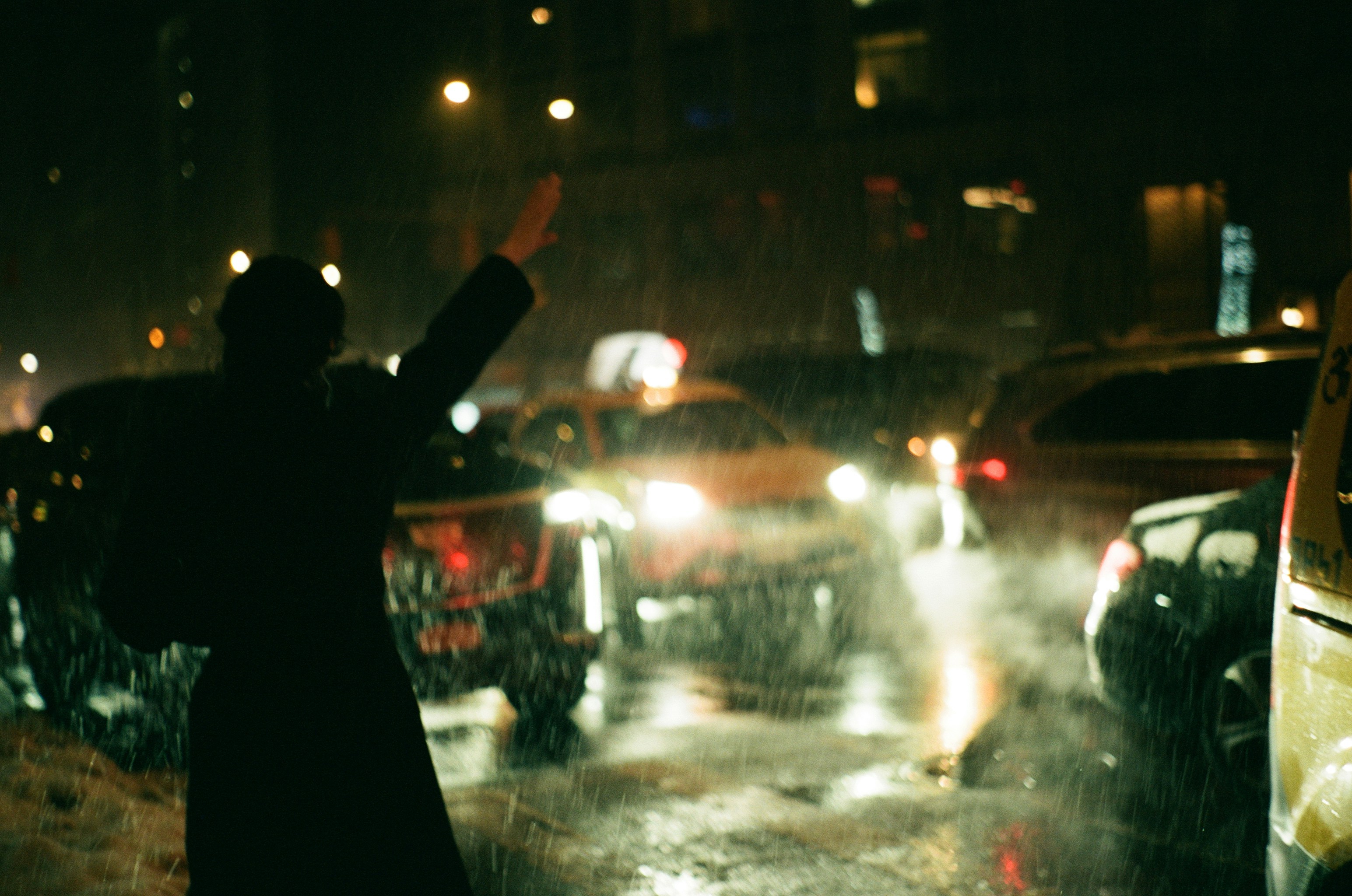 A person standing in the rain with their arms in the air