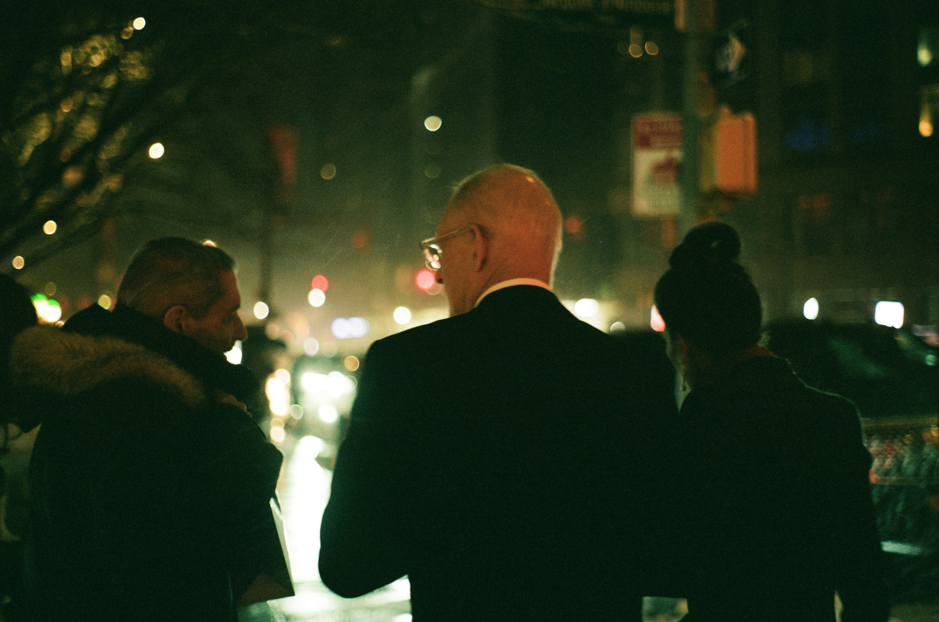 People walking down a Manhattan street at night