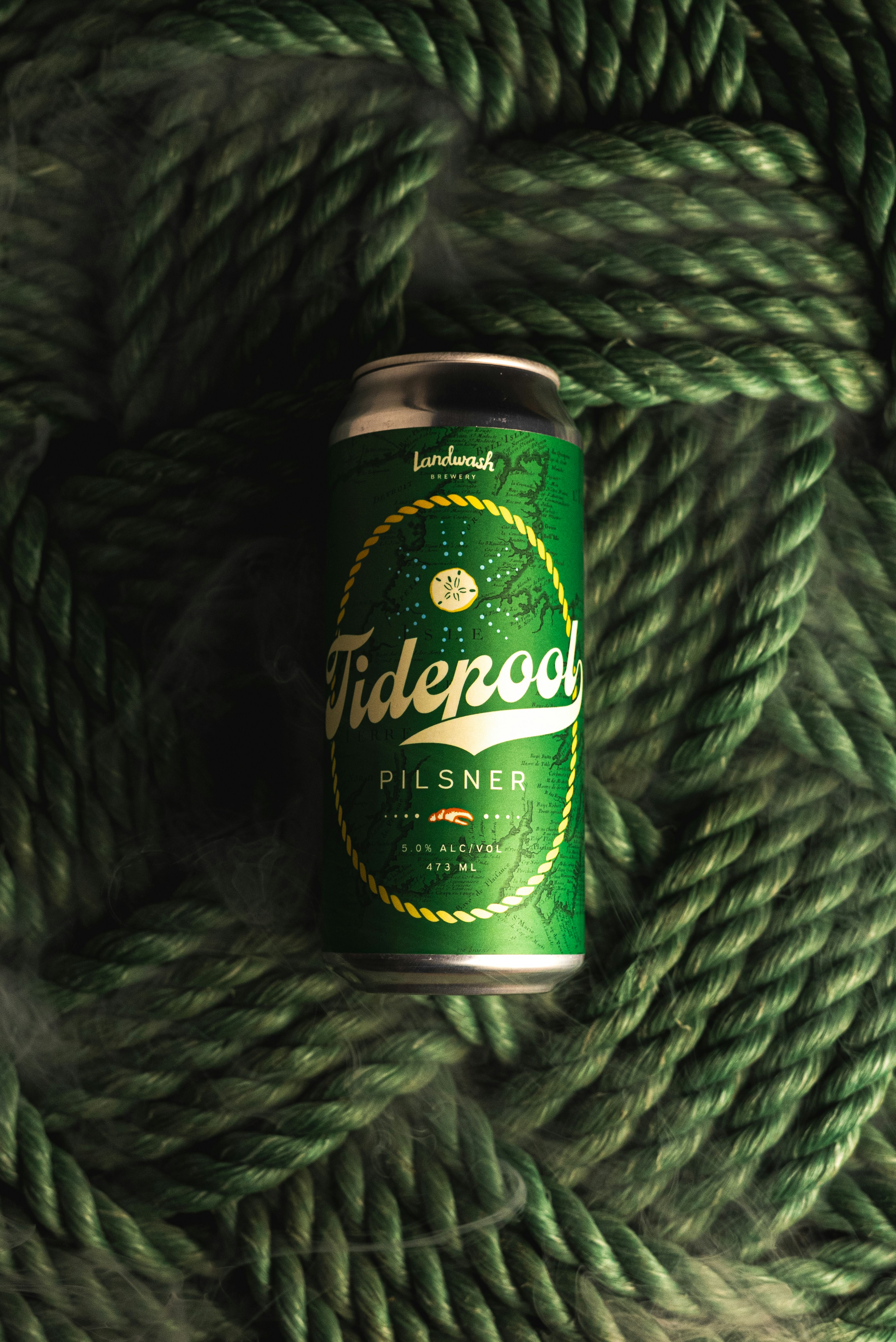 Una lata de cerveza encima de una cuerda verde