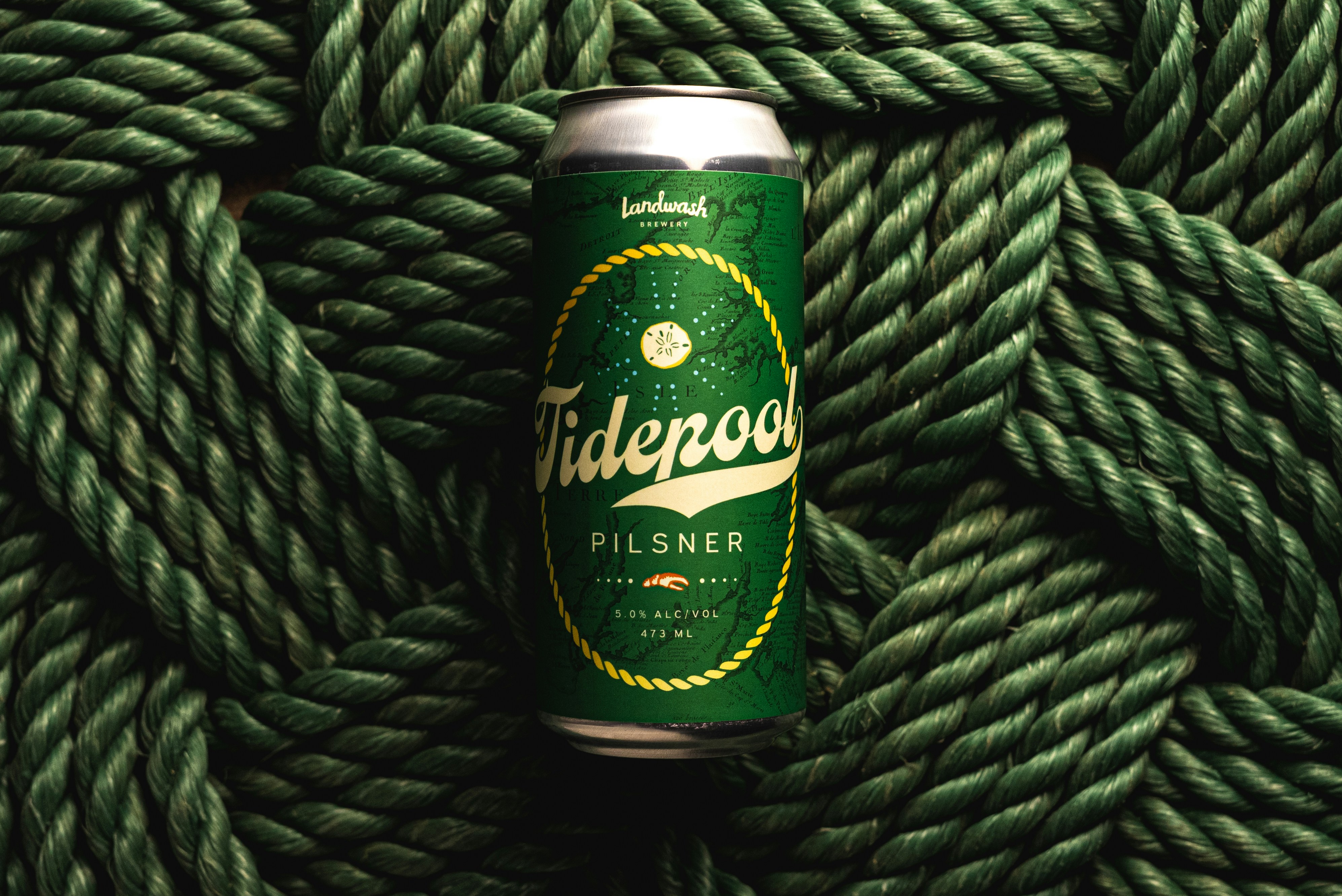 Una lata de cerveza encima de una cuerda verde