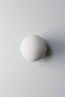 A white egg sitting on top of a white table