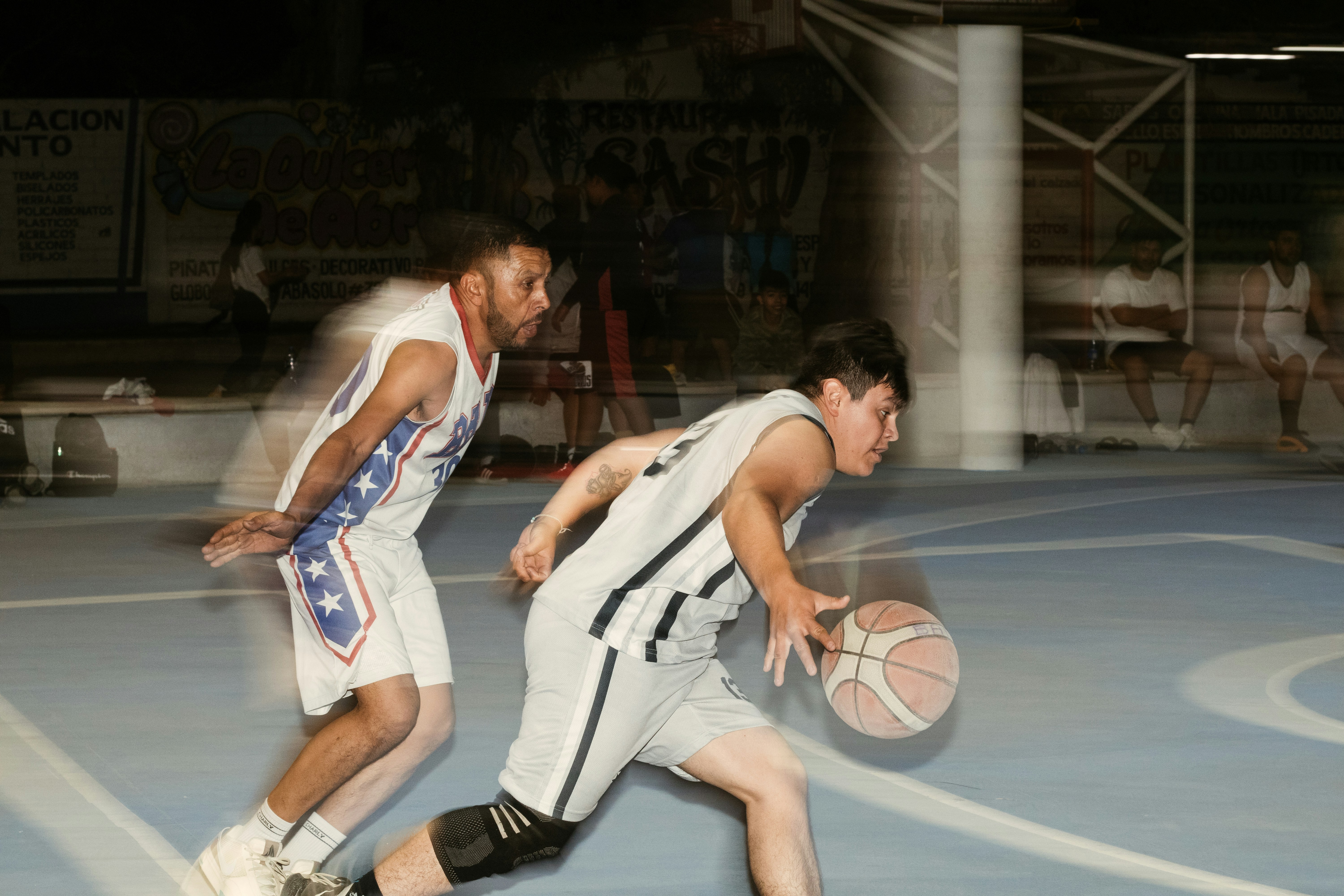 A couple of men playing a game of basketball