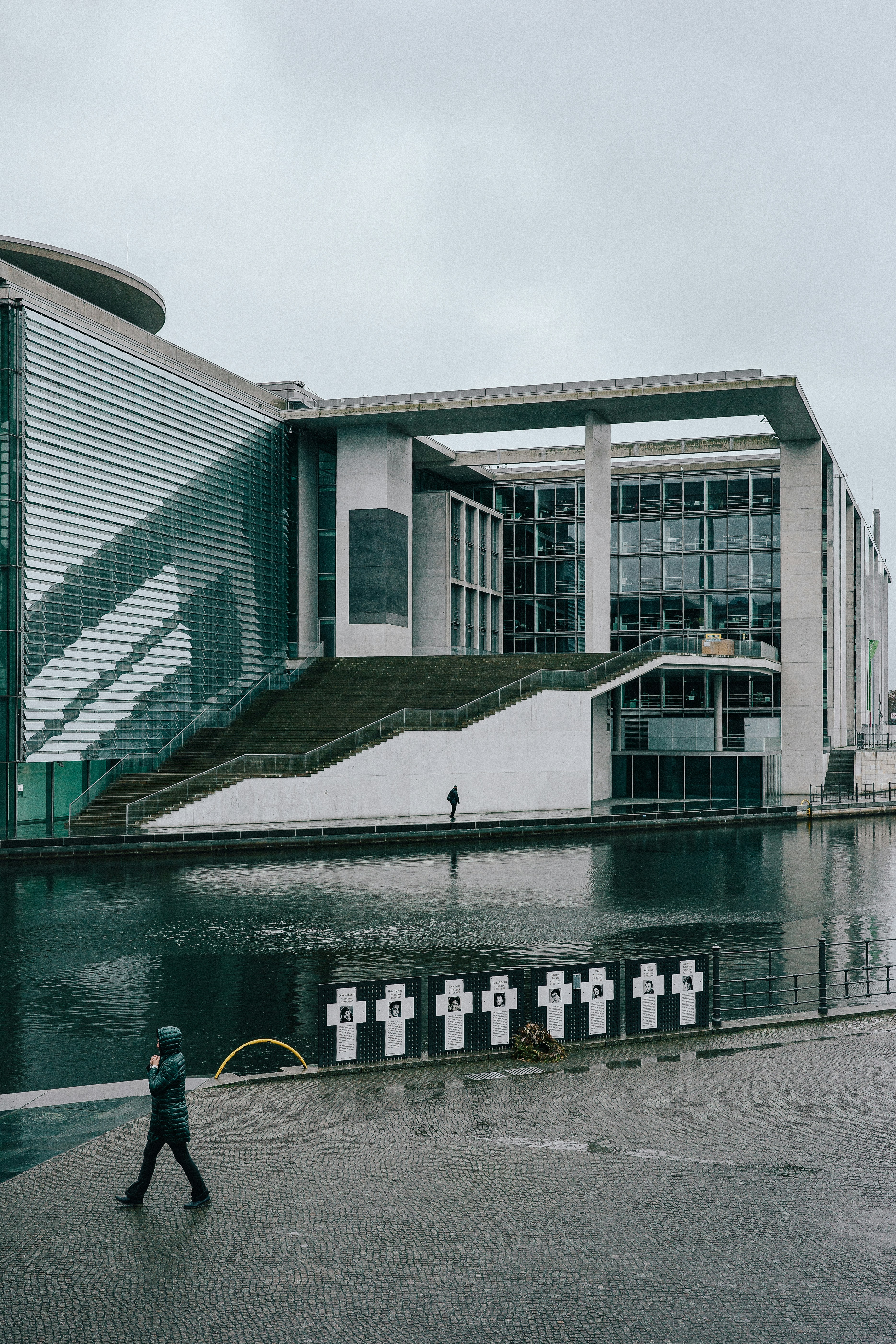 A person walking in front of a large building