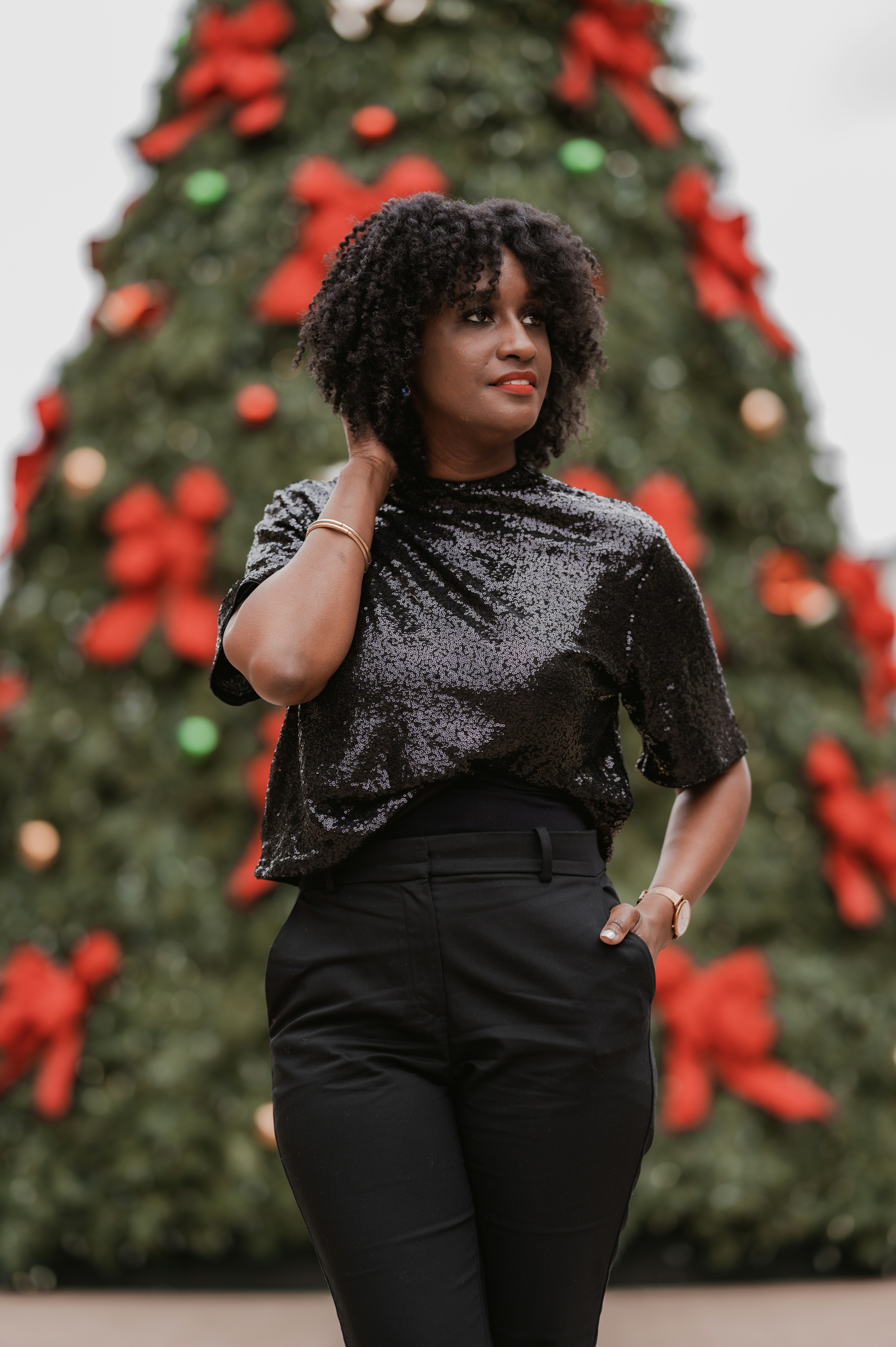A woman standing in front of a christmas tree