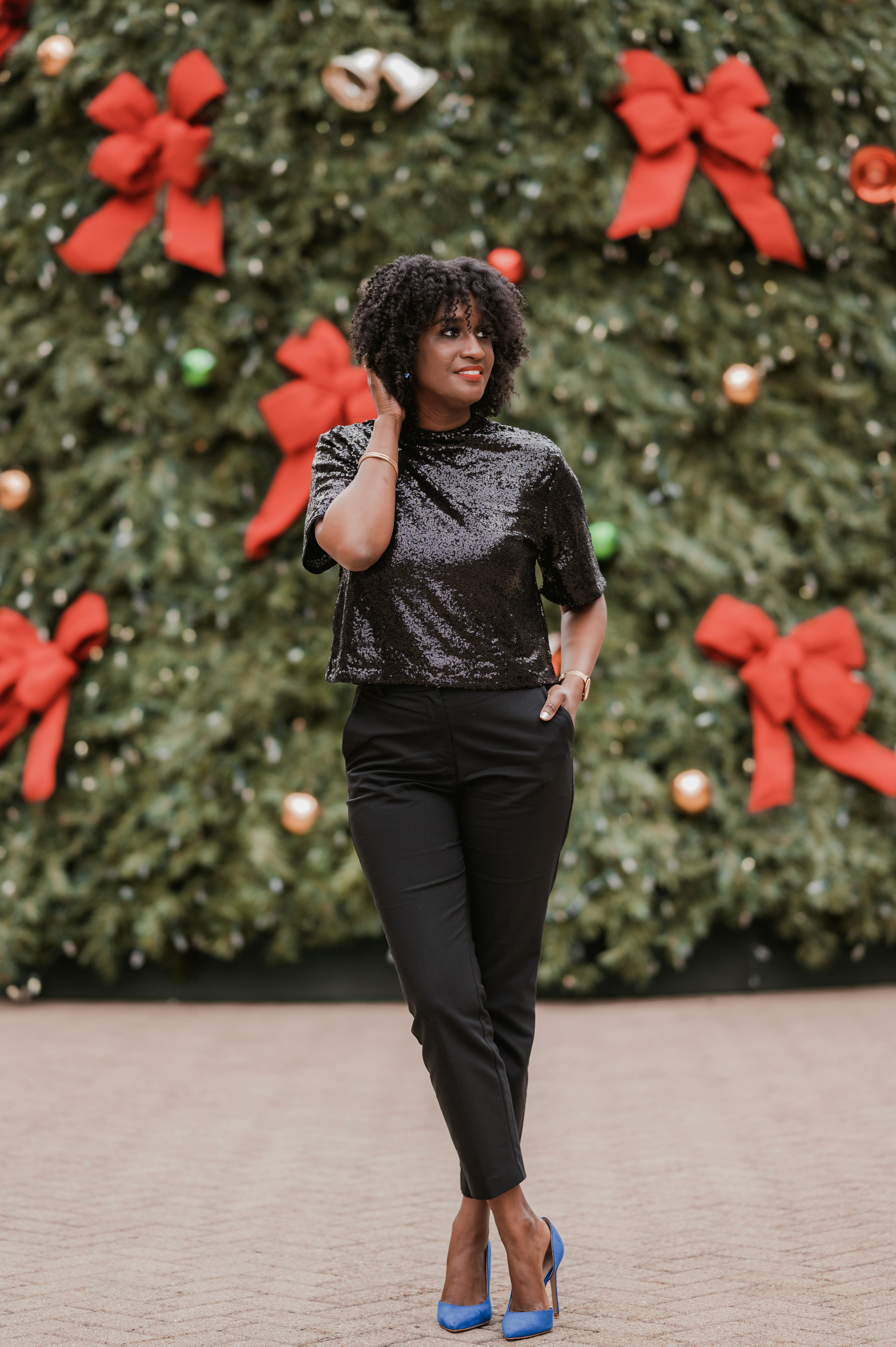 A woman standing in front of a christmas tree