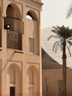 A tall building with a palm tree in front of it