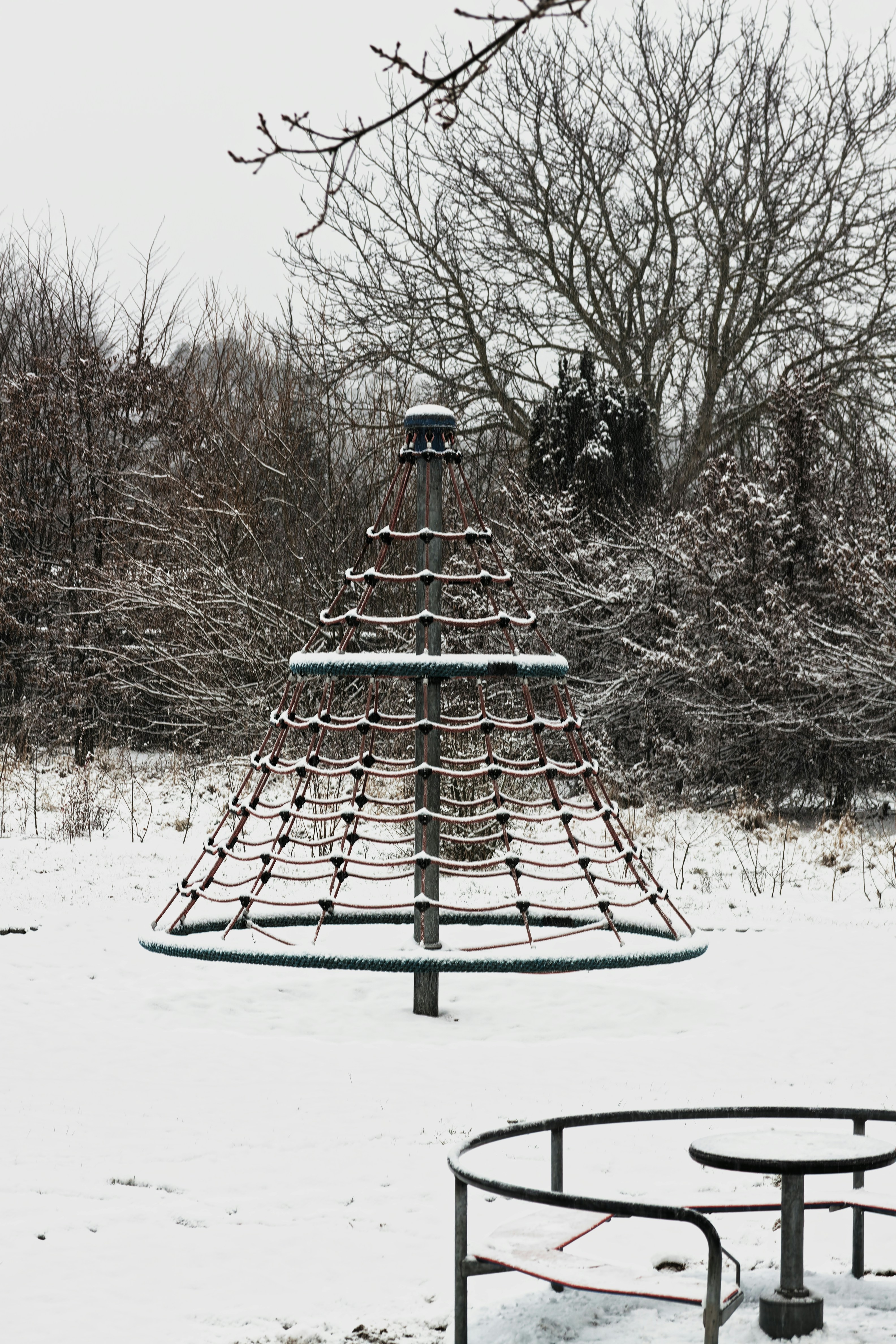 A large metal structure sitting in the middle of a snow covered field