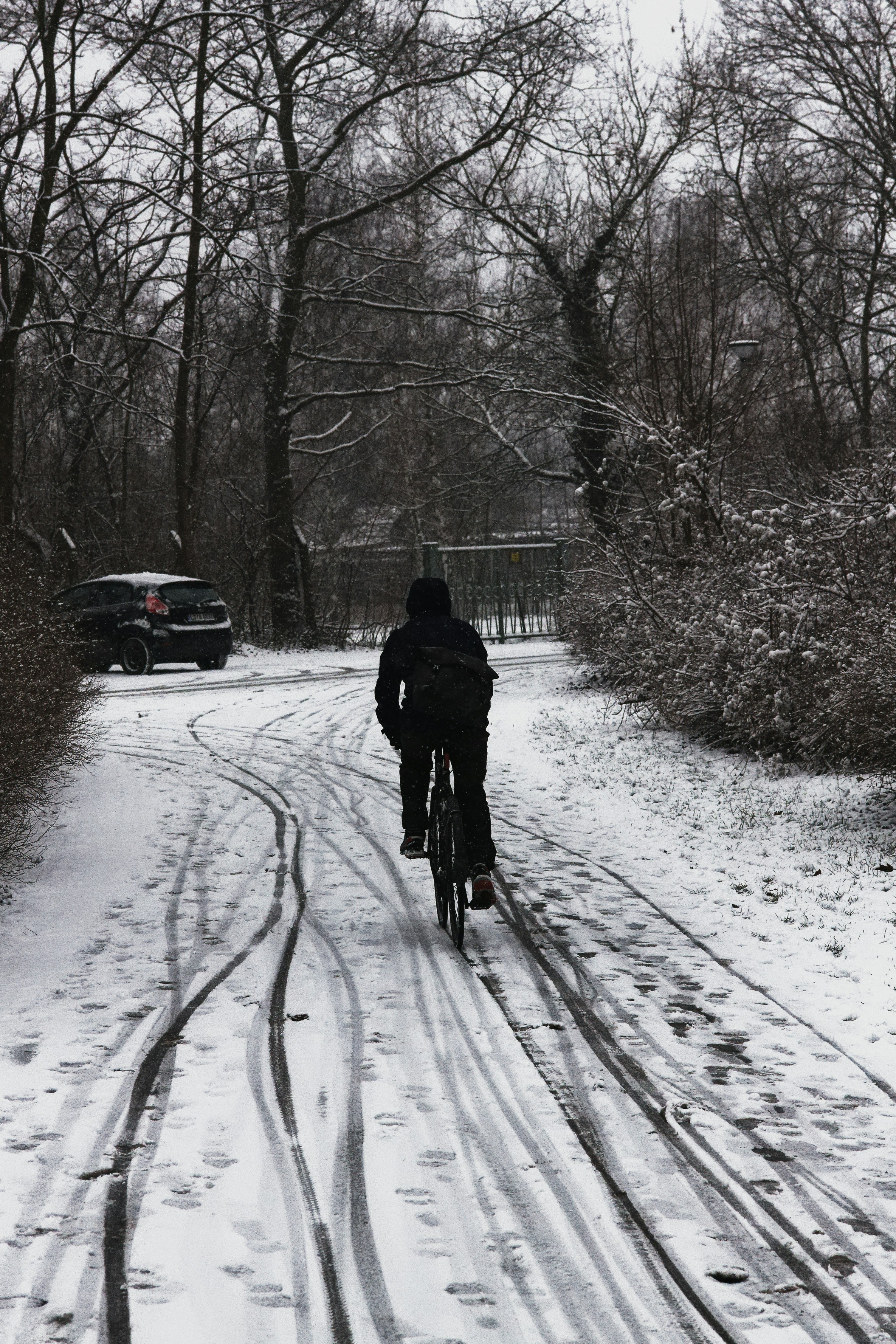 A person riding a bike down a snow covered road