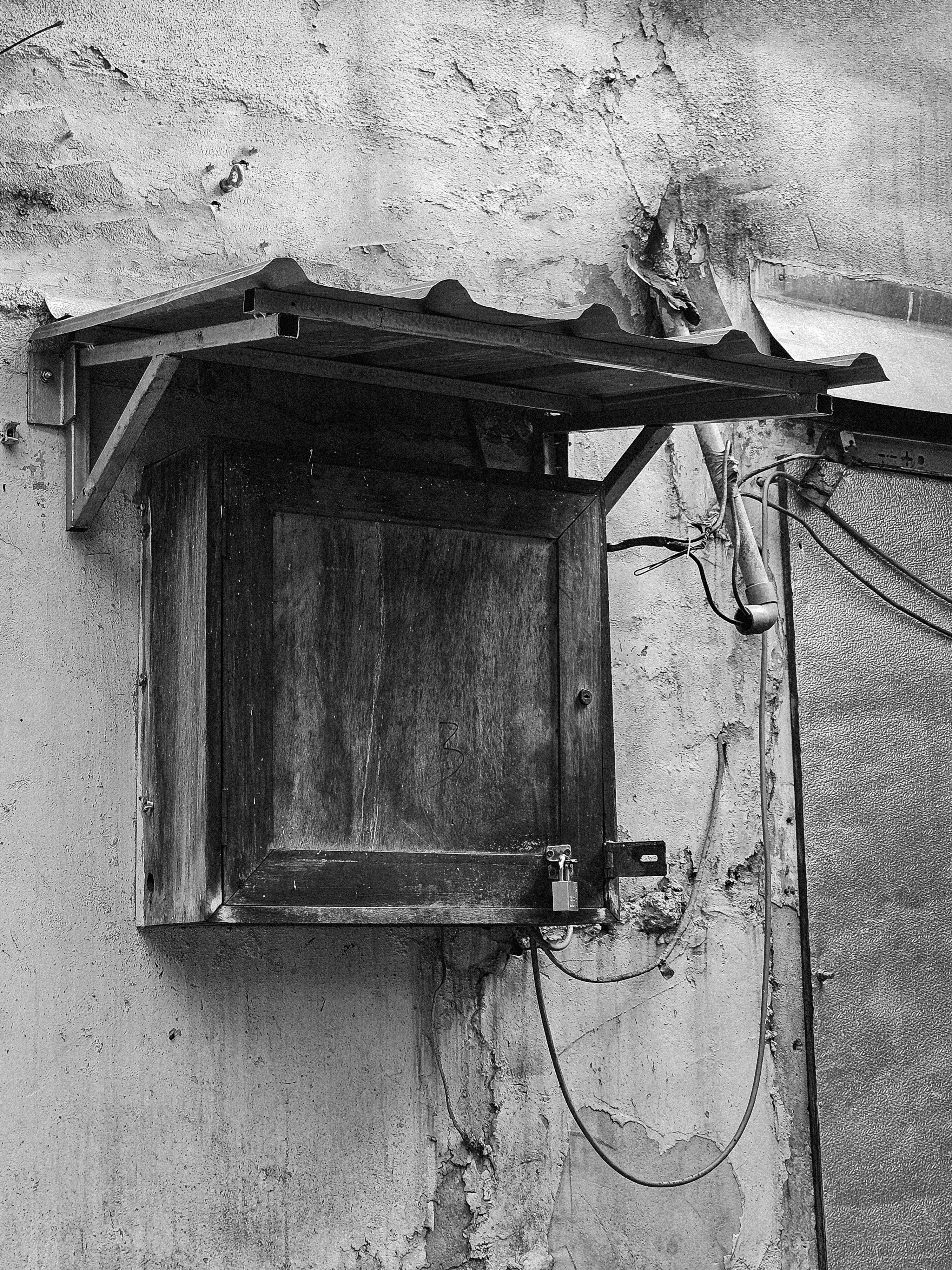 A black and white photo of a window on a wall