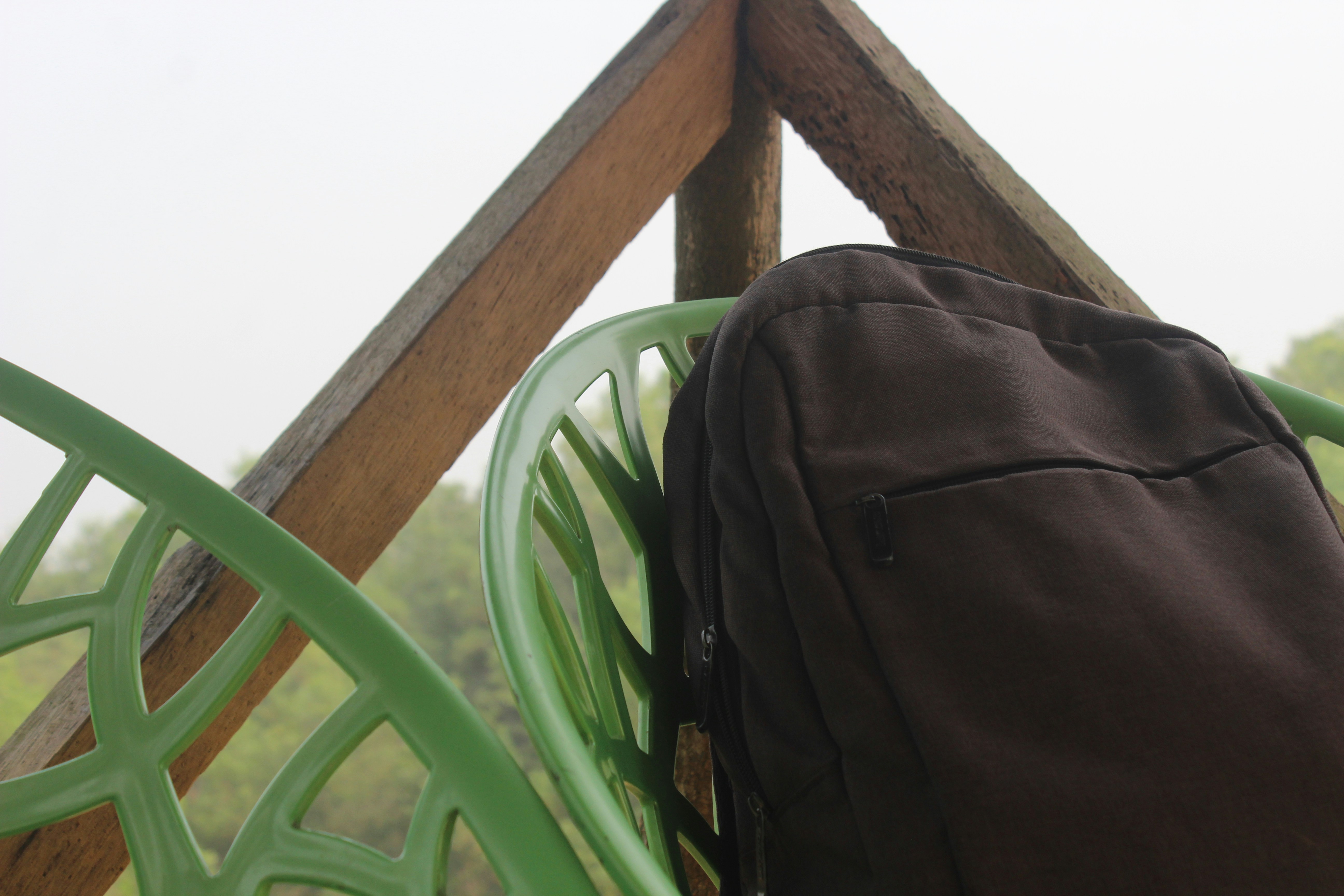 A back pack sitting on top of a green chair