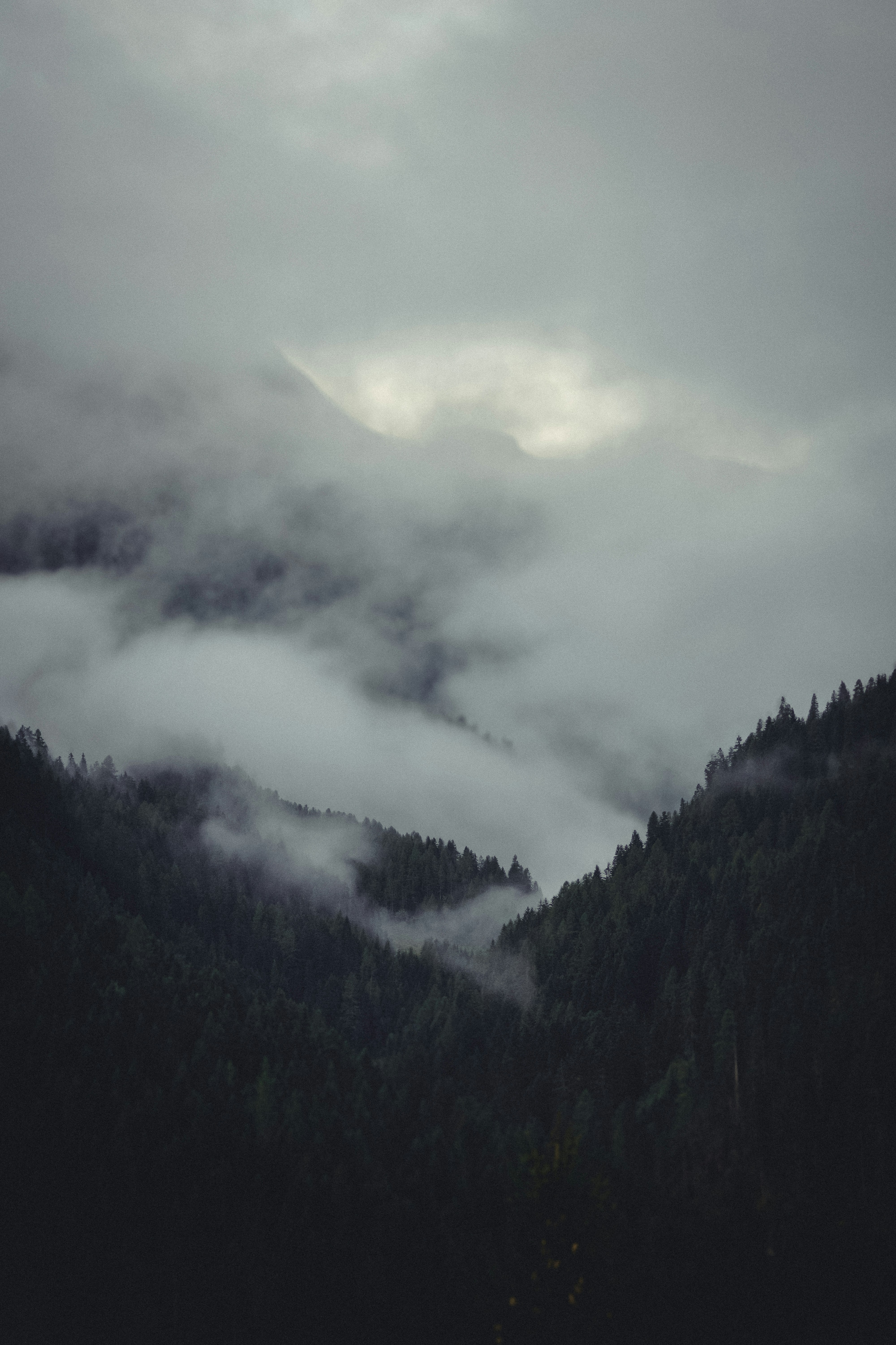 A mountain covered in fog and low lying clouds