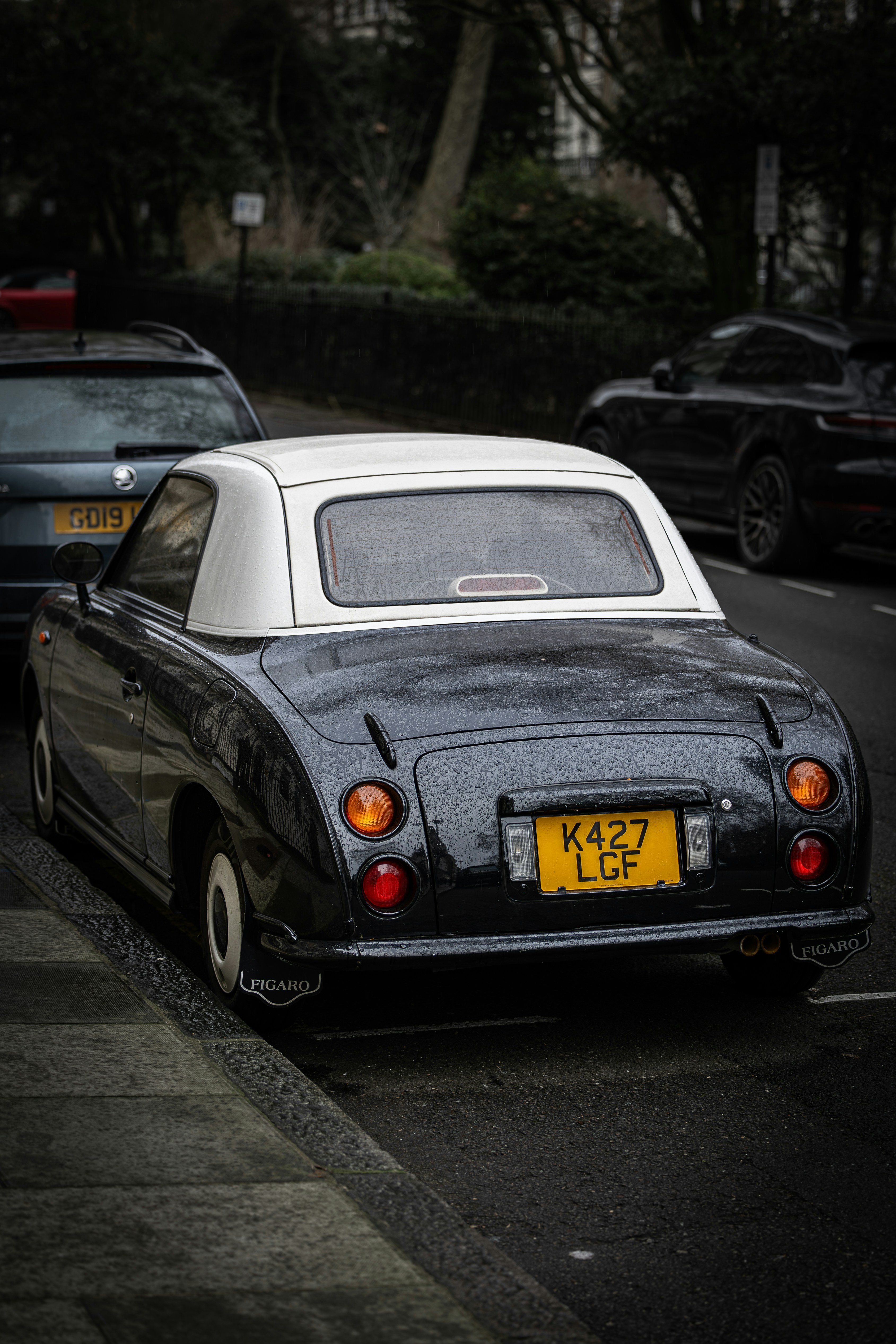 A black and white car parked on the side of the road