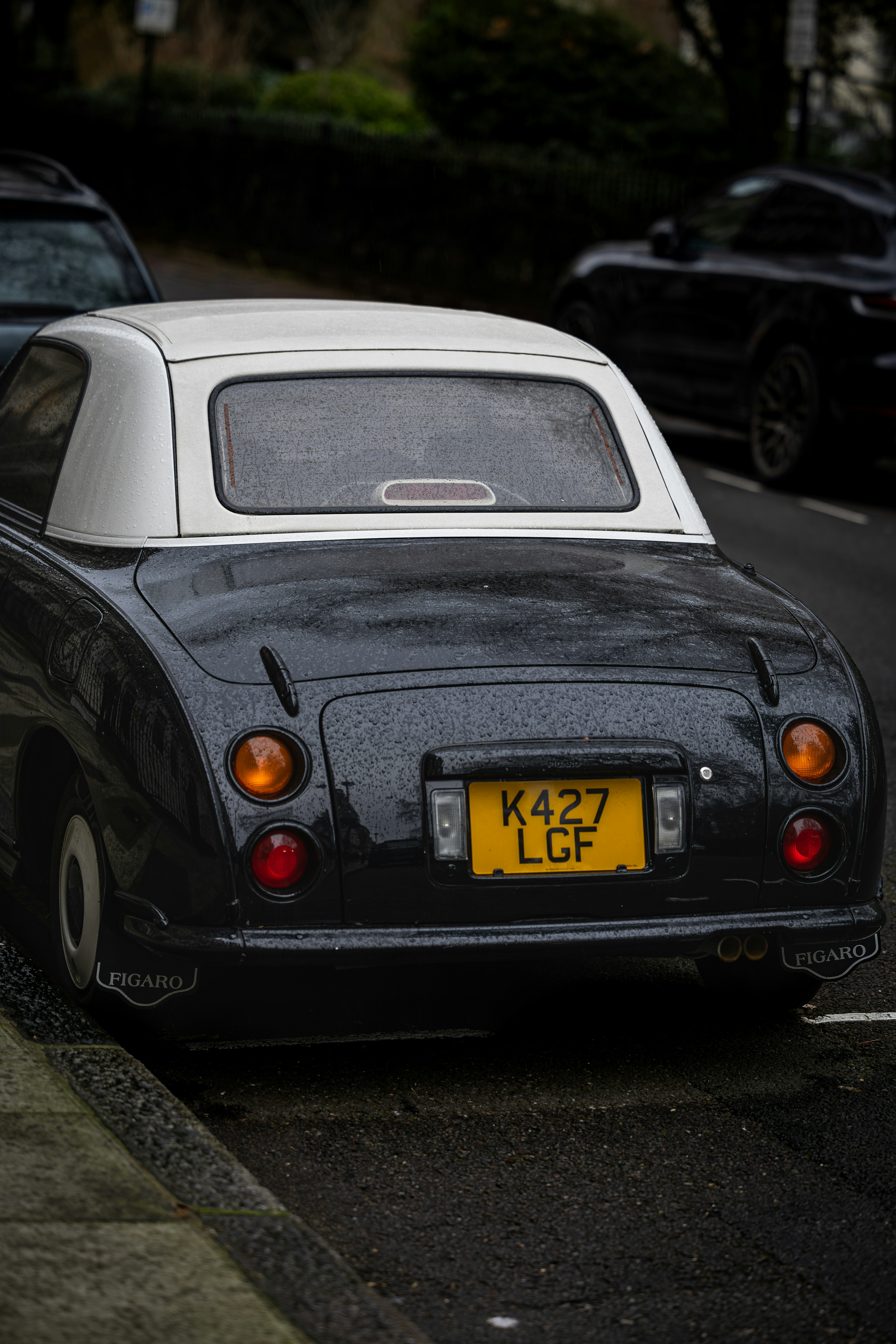 A black and white car parked on the side of the road