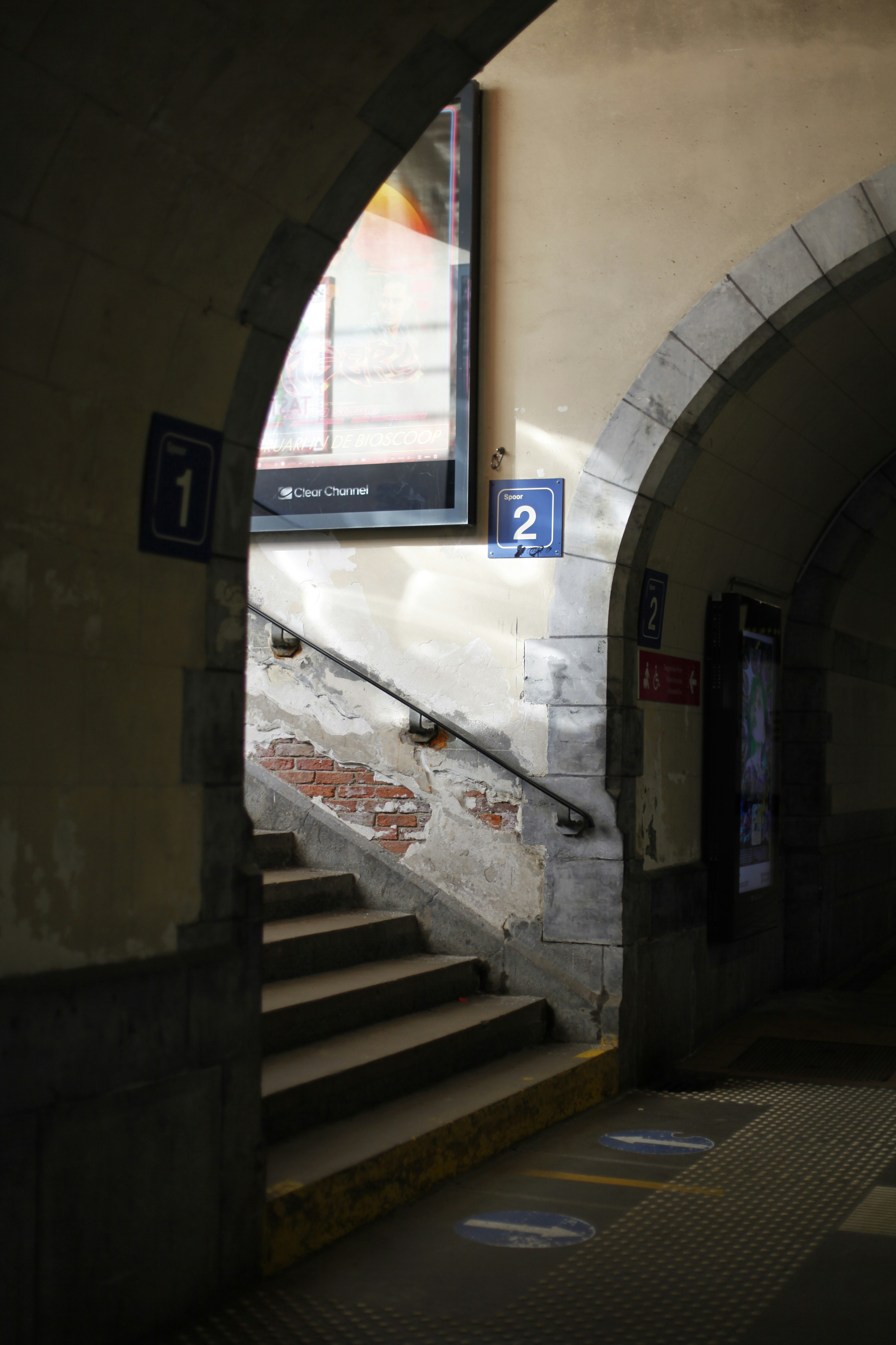 A tunnel with a sign and stairs leading up to it