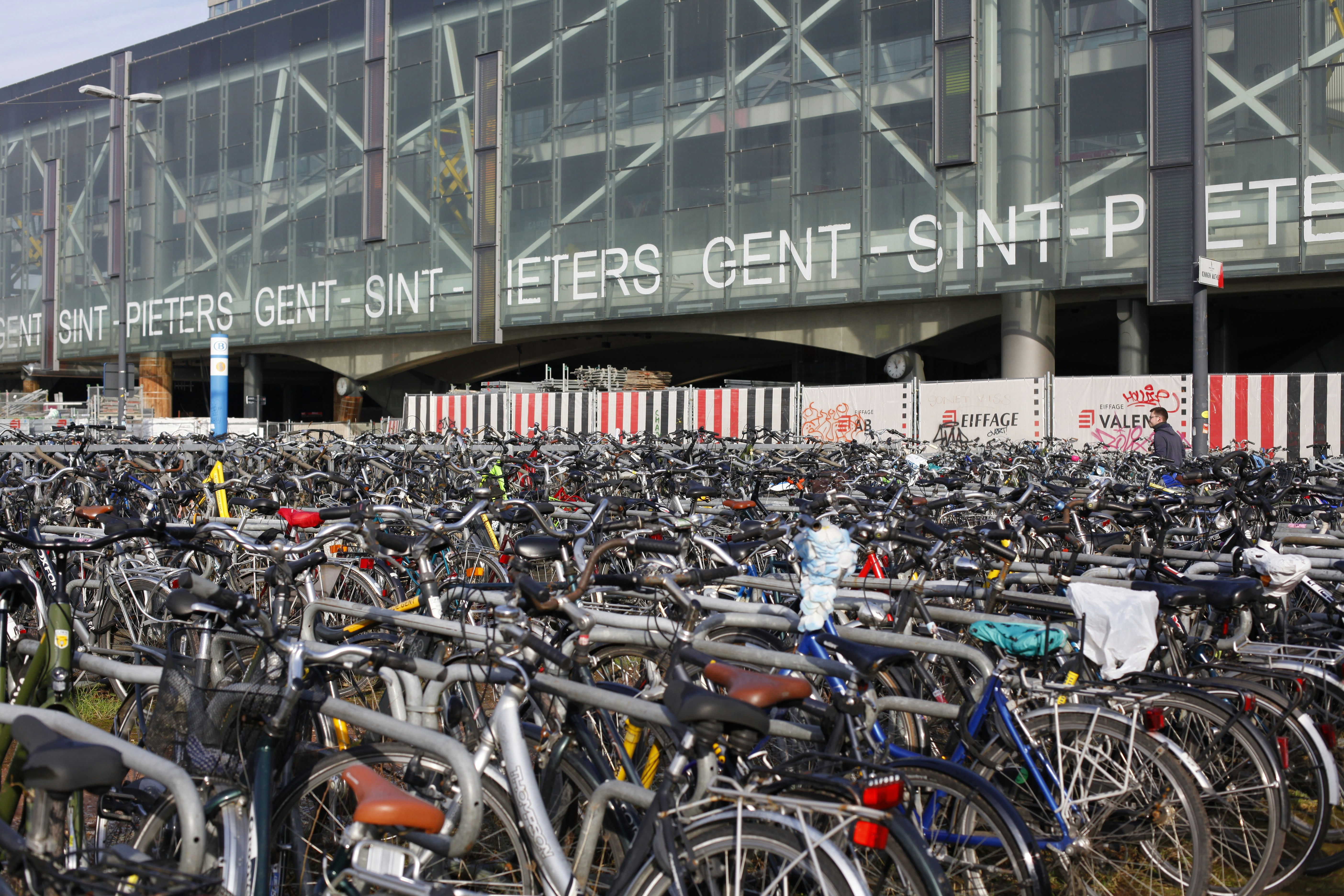 A large amount of bicycles parked in a parking lot