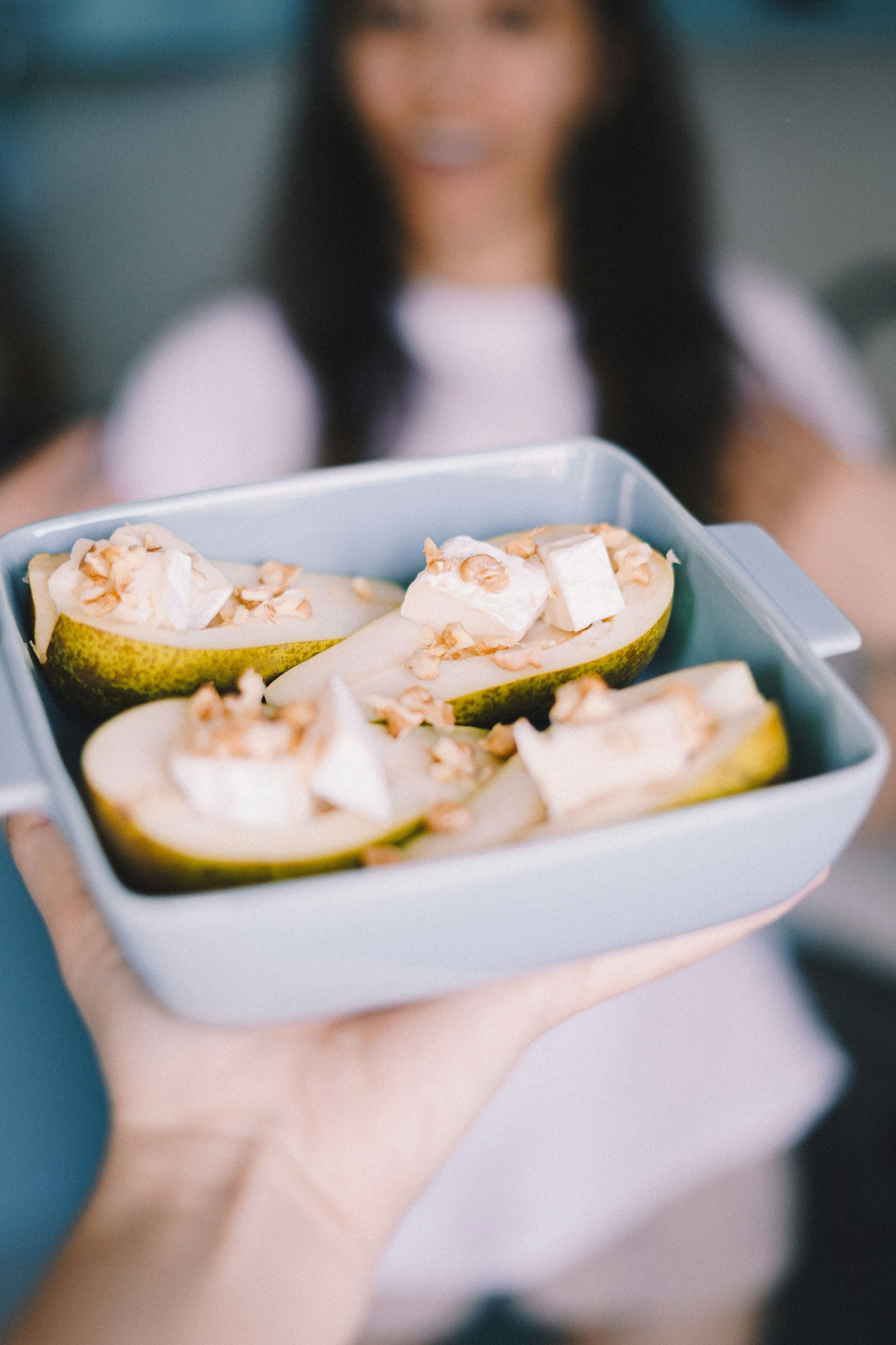 A woman holding a tray of food in her hand