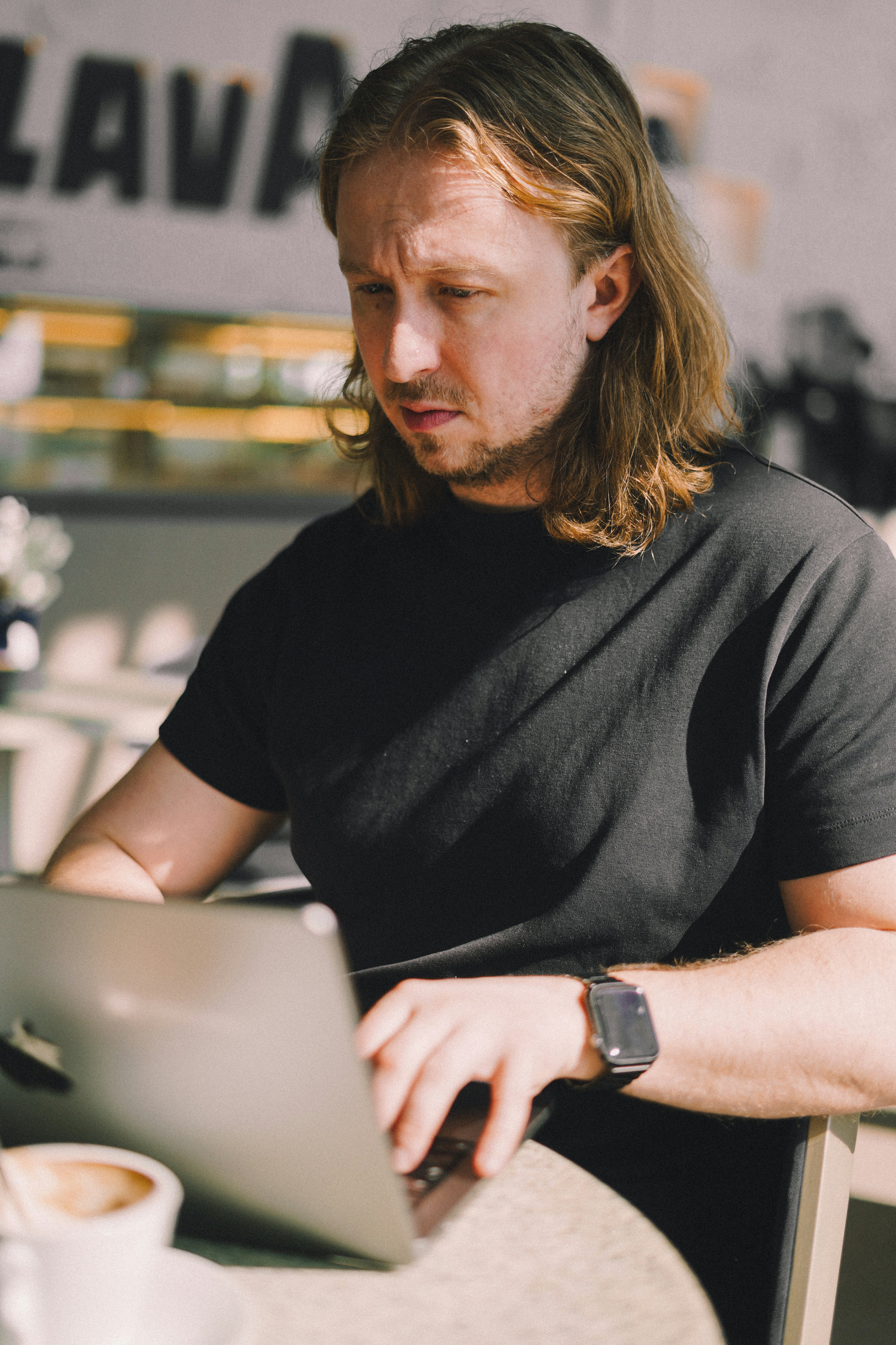 A man sitting at a table using a laptop computer
