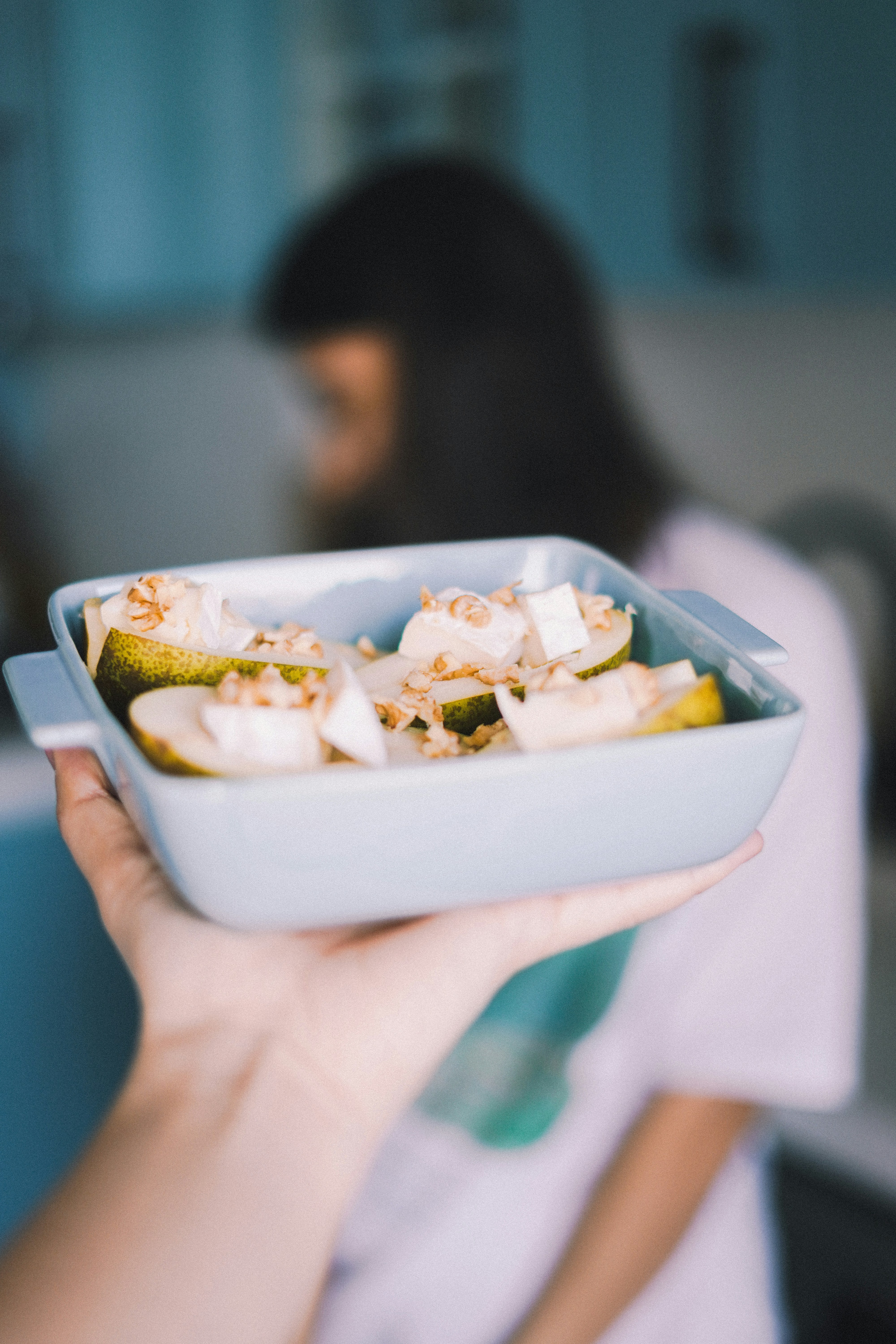 A person holding a container of food in their hand