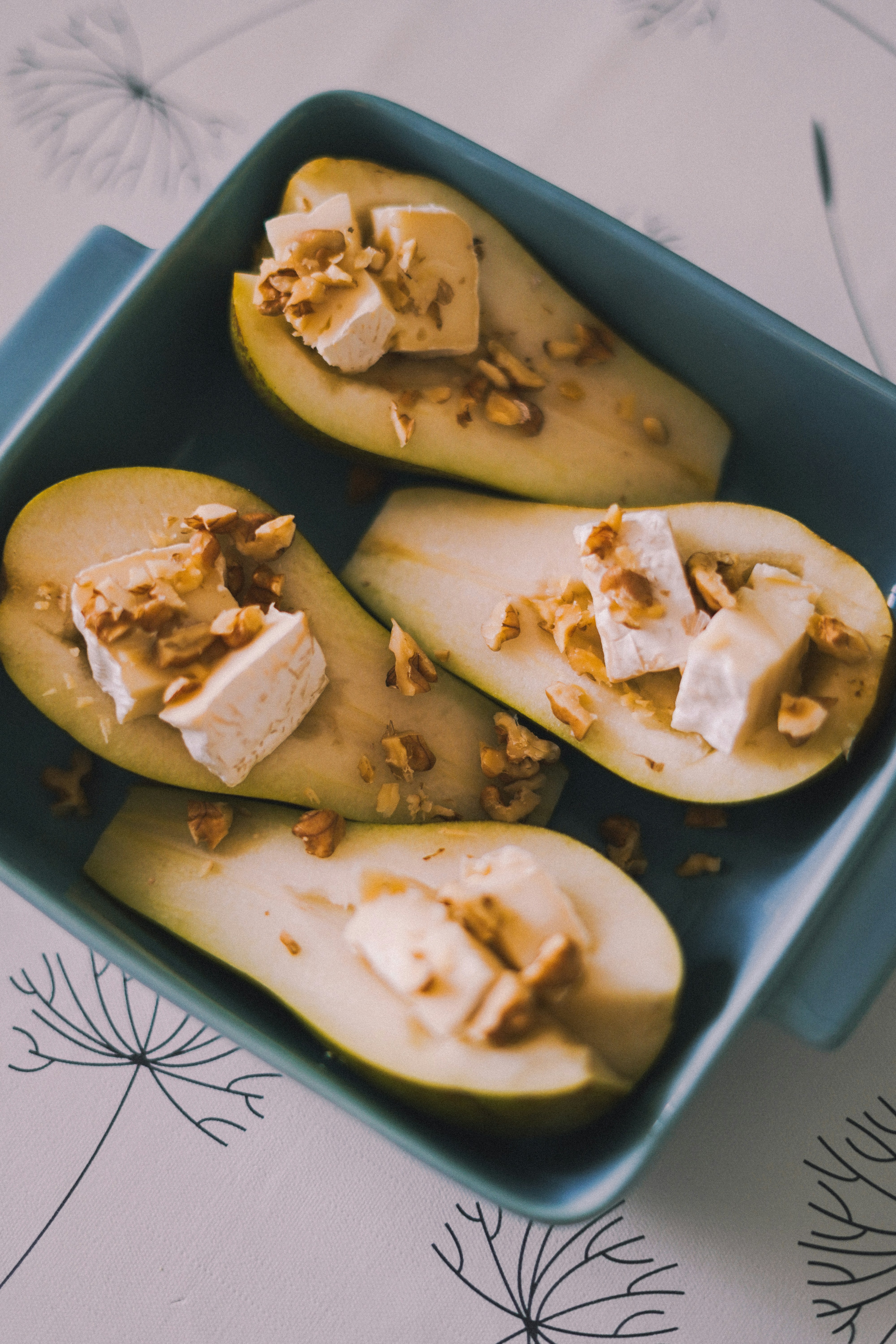 A blue dish filled with sliced pears on a table