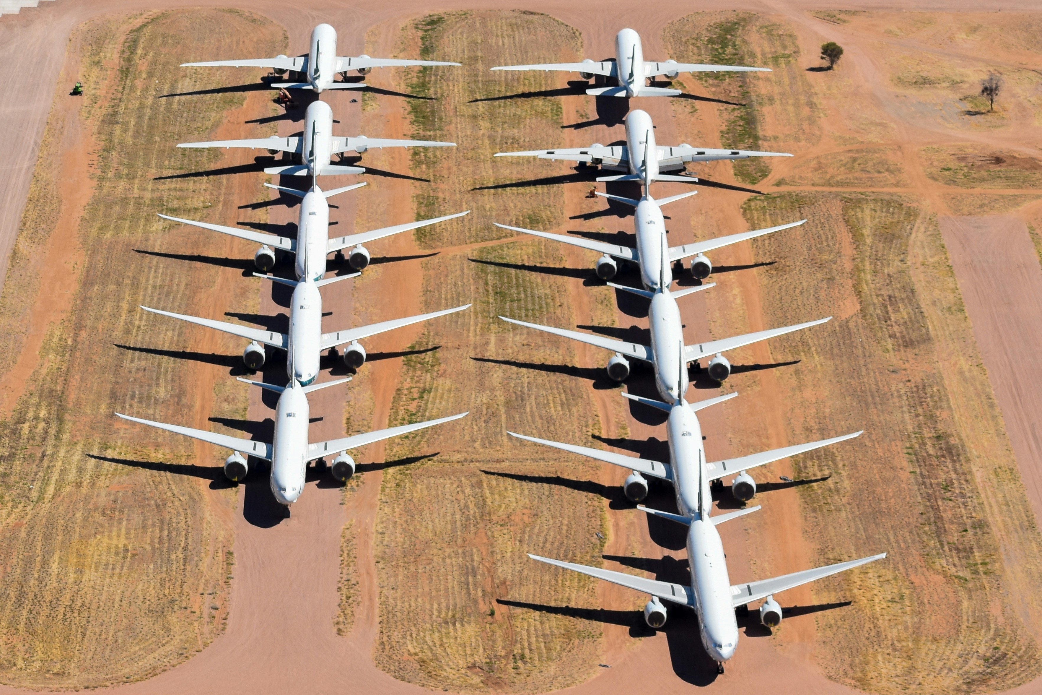 A large group of airplanes parked in a field, Cathay Pacific Boeing 777s stored at Alice Springs in August 2022