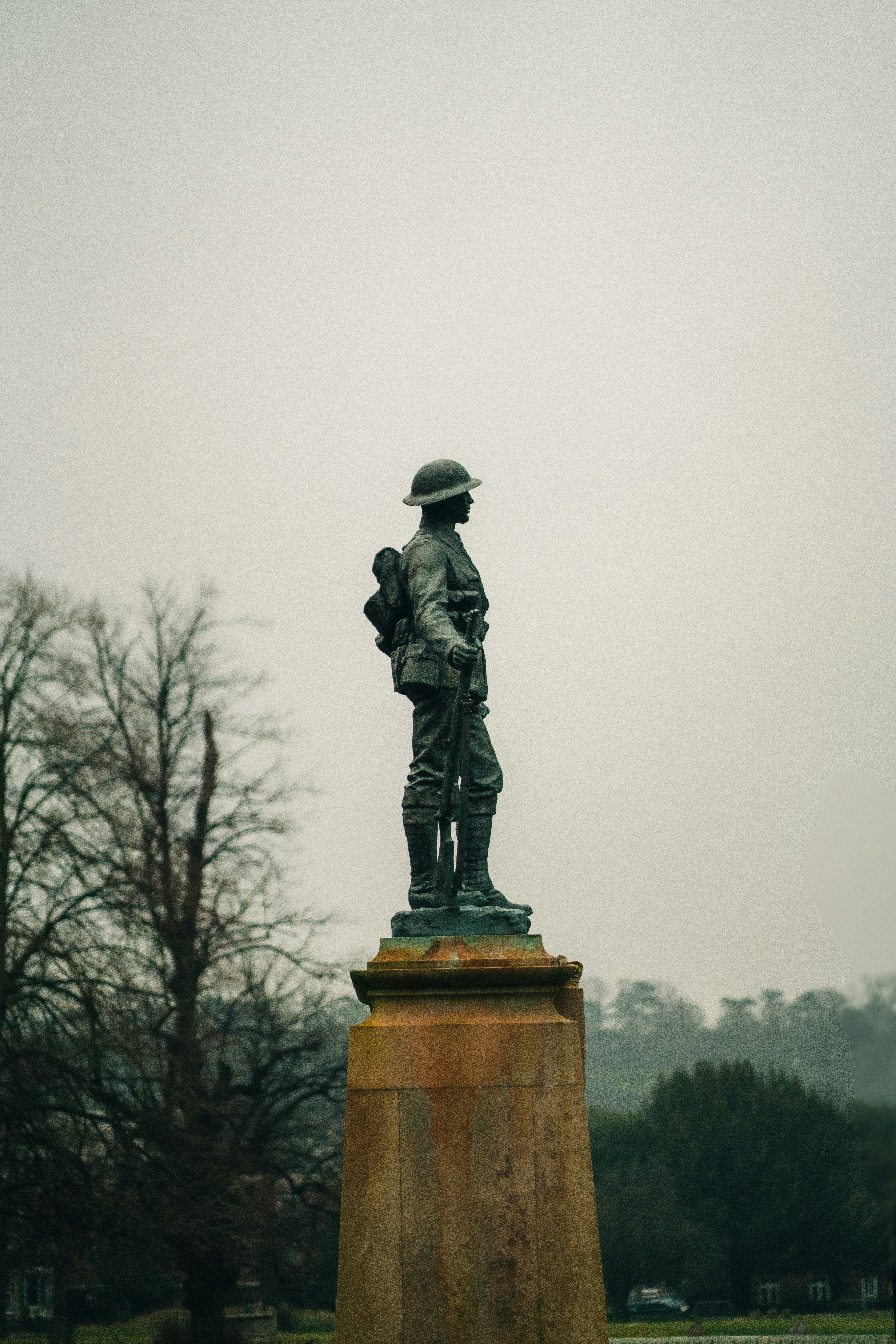Una estatua de un hombre sosteniendo una pistola en un parque