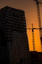 A tall building with a crane in the background