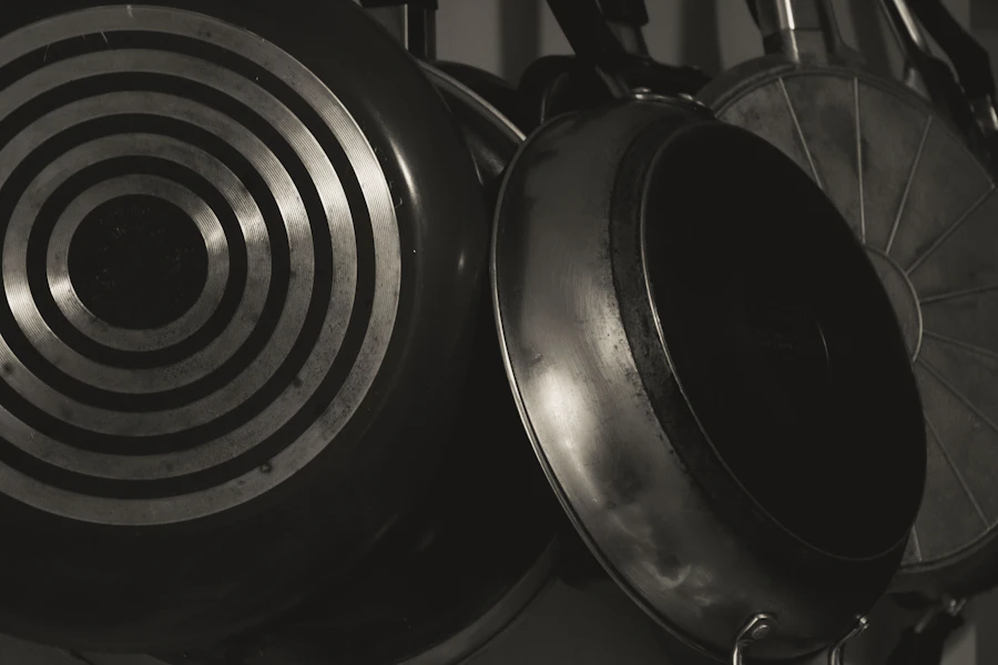 Monochrome close-up of hanging pans showing concentric machined rings and polished rims