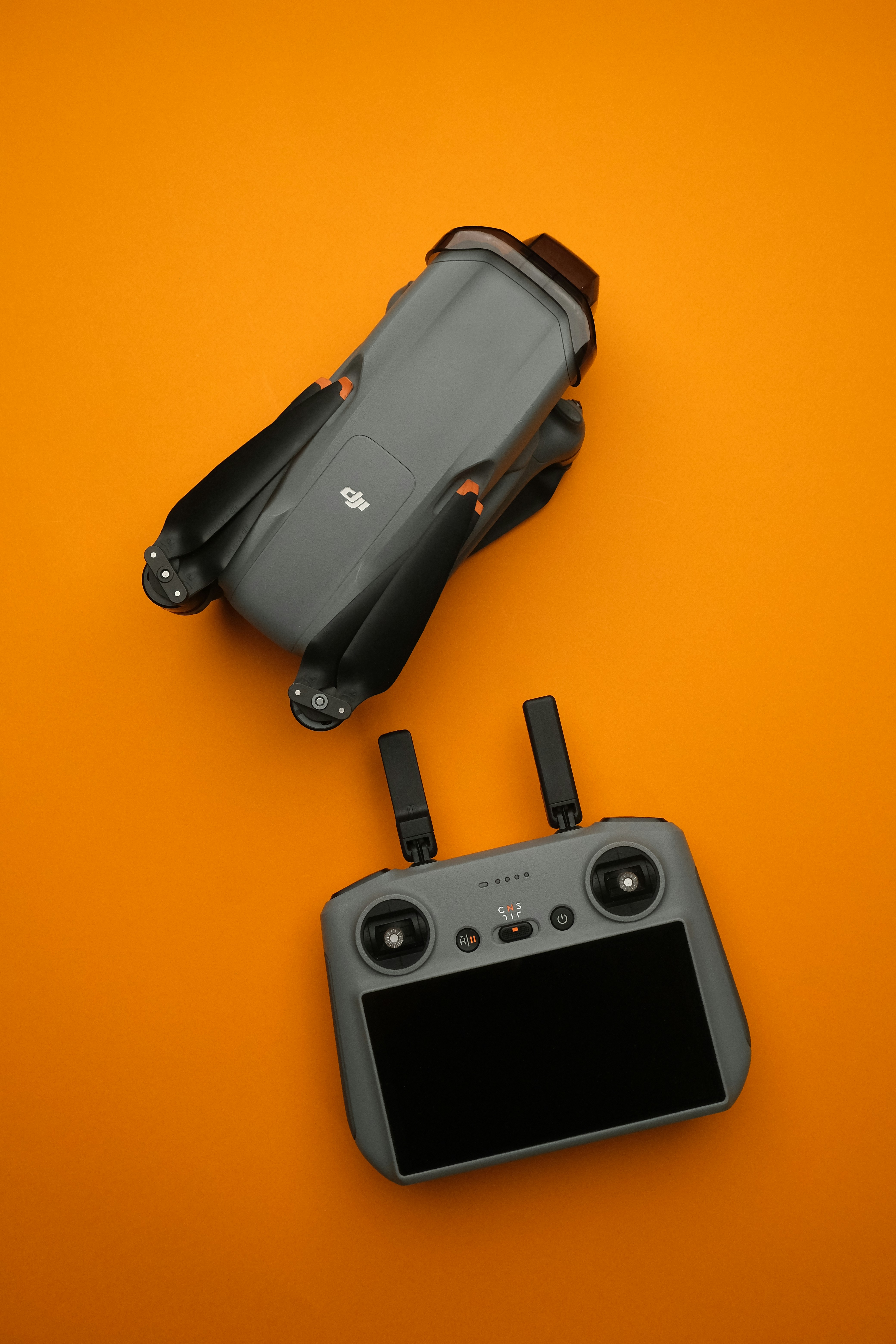 A camera and a remote control on an orange background