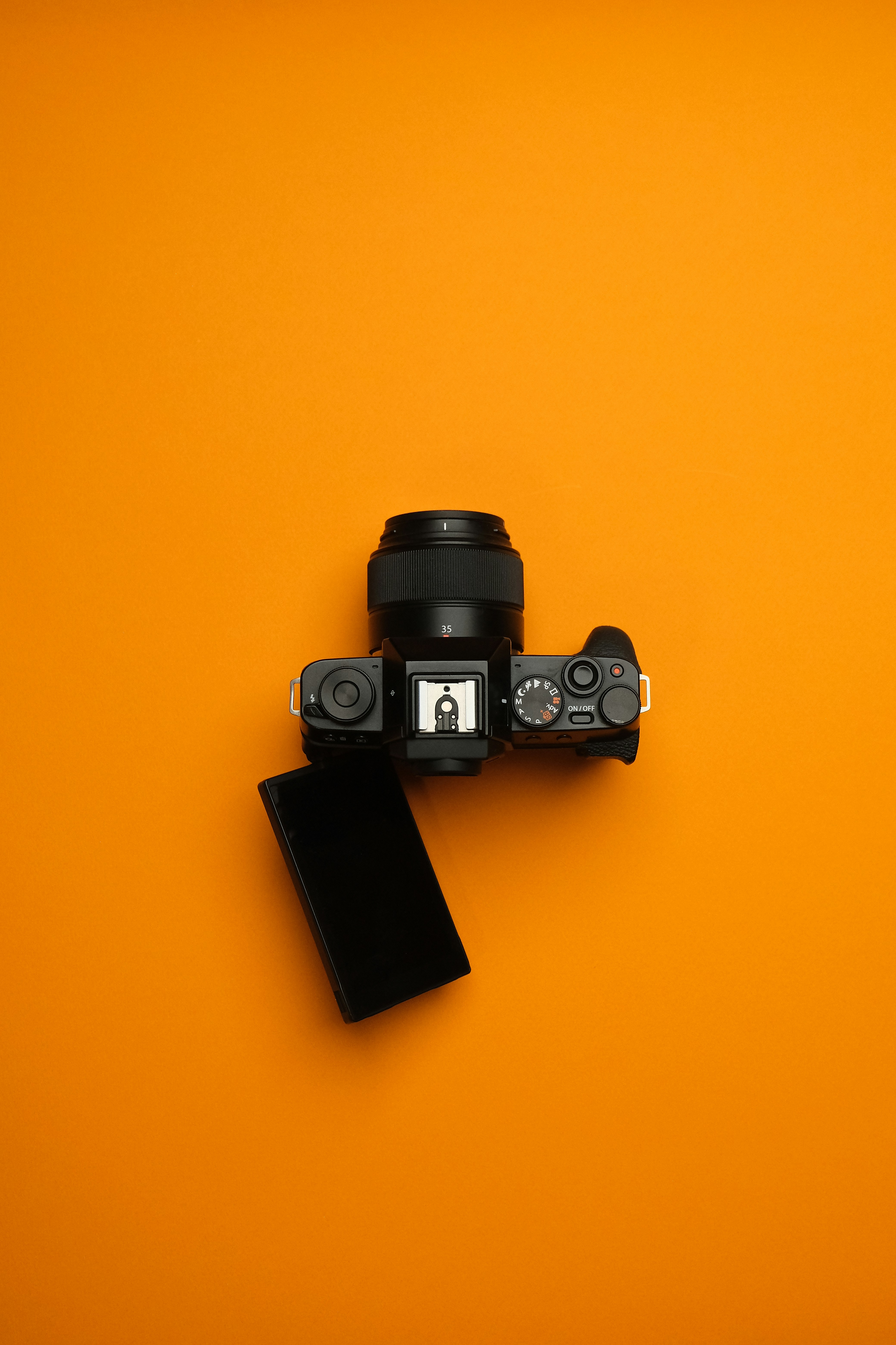 A camera sitting on top of an orange surface
