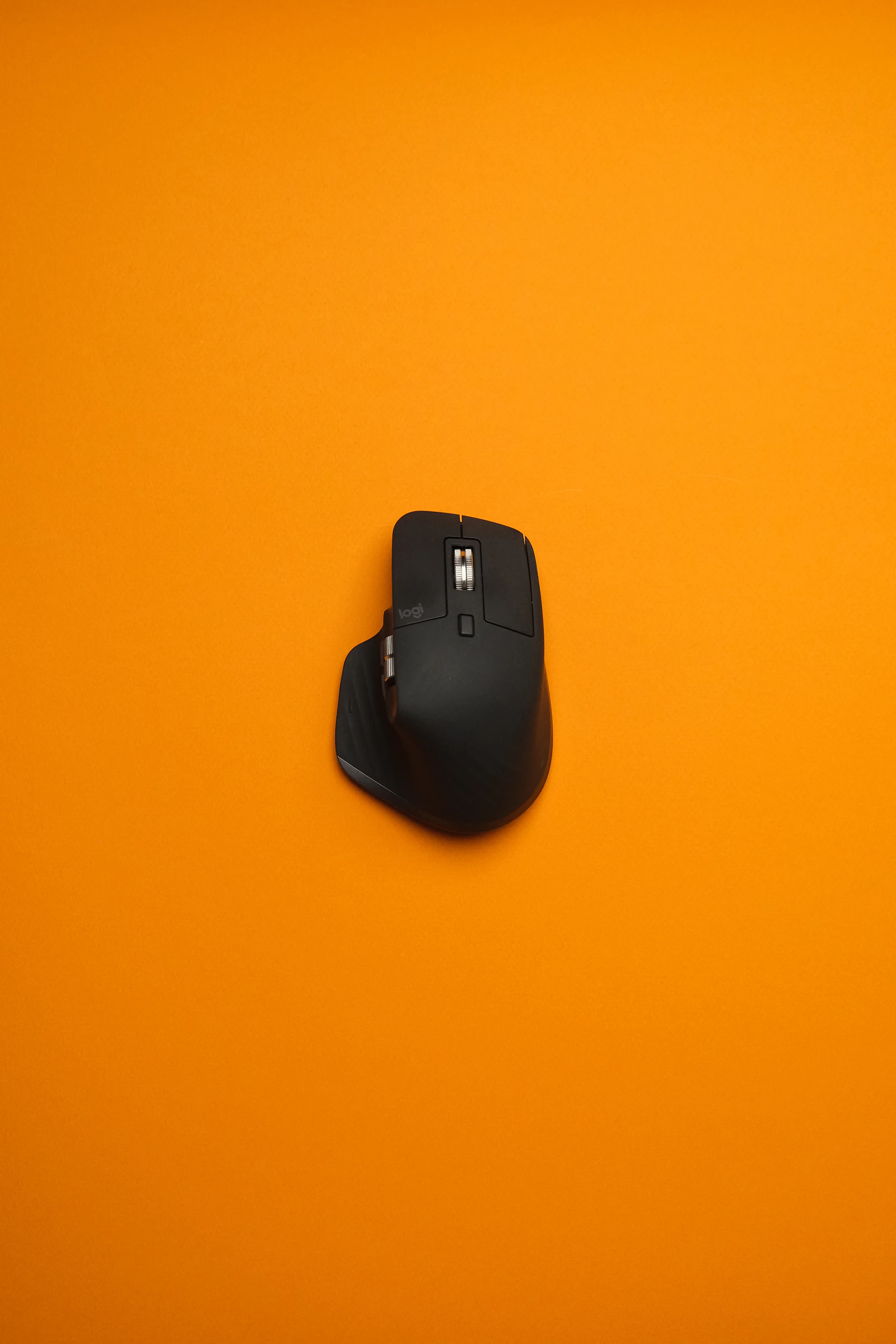 Logitech MX Master 3S wireless mouse on an orange background