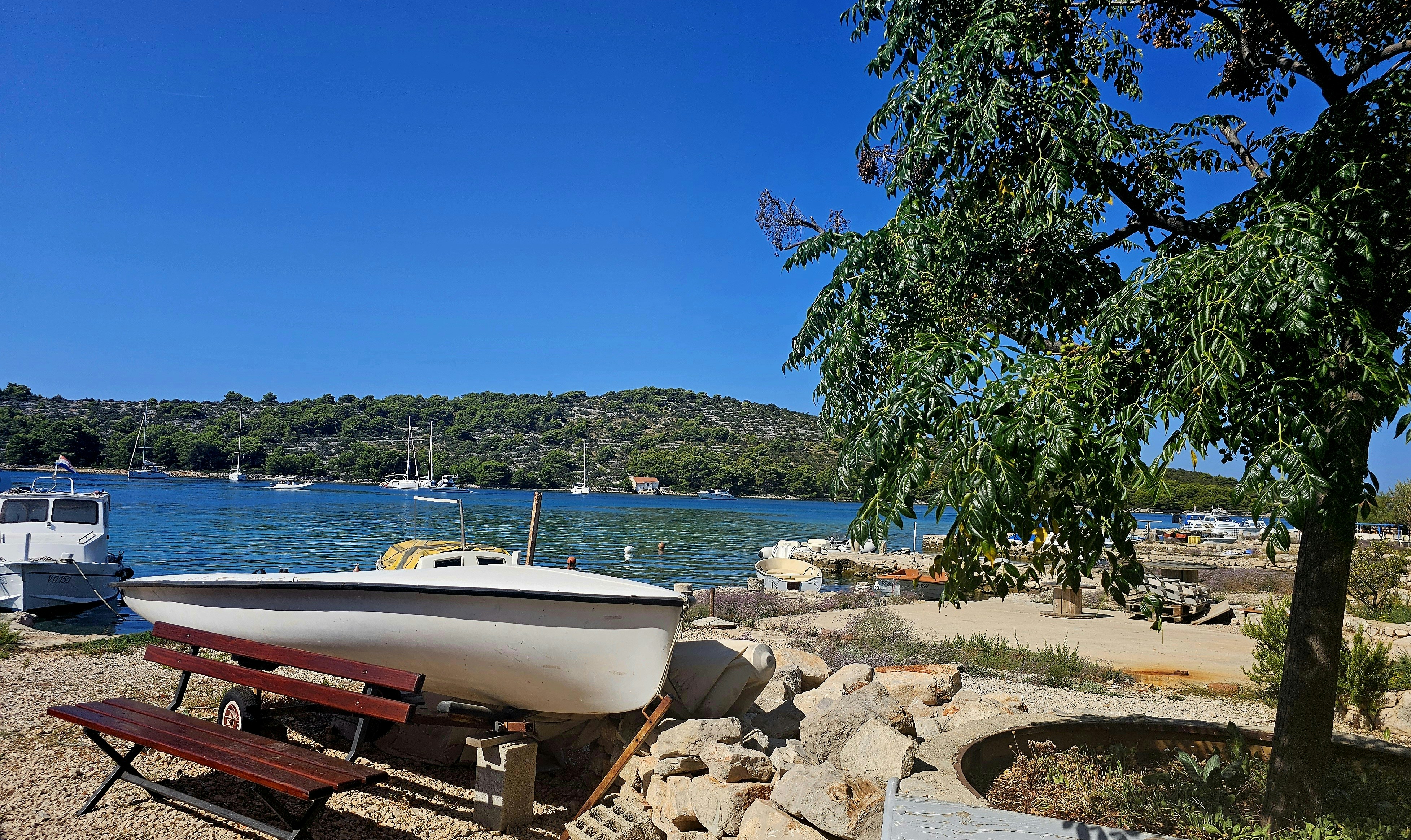 A boat sitting on the shore of a lake