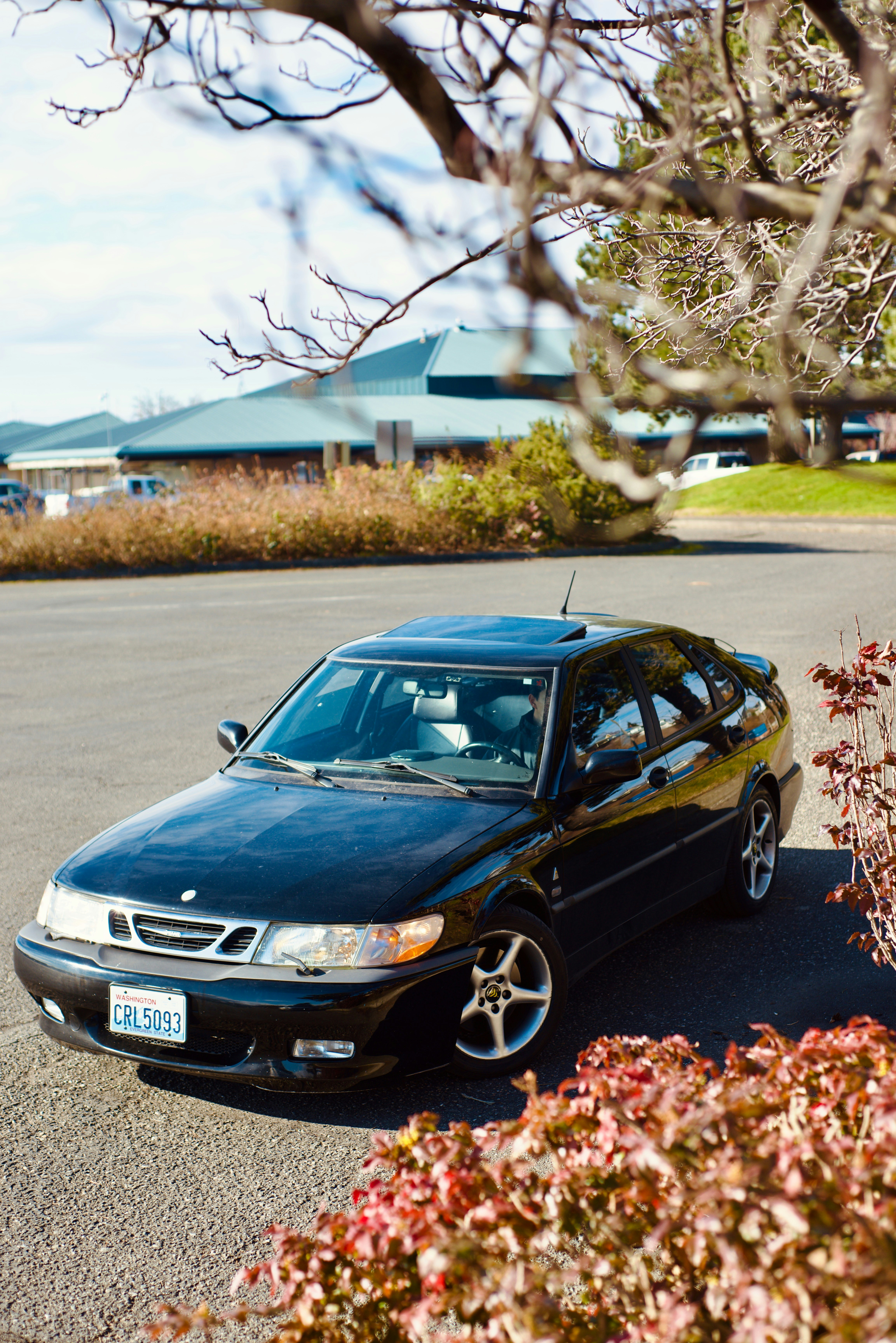 Un coche negro aparcado en un aparcamiento