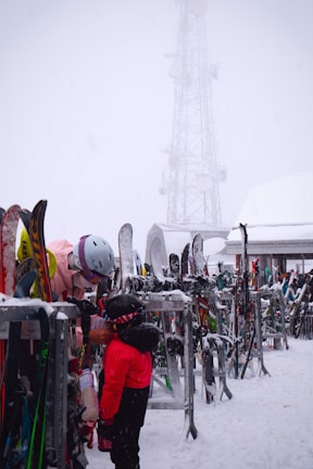 A person standing next to a rack of skis