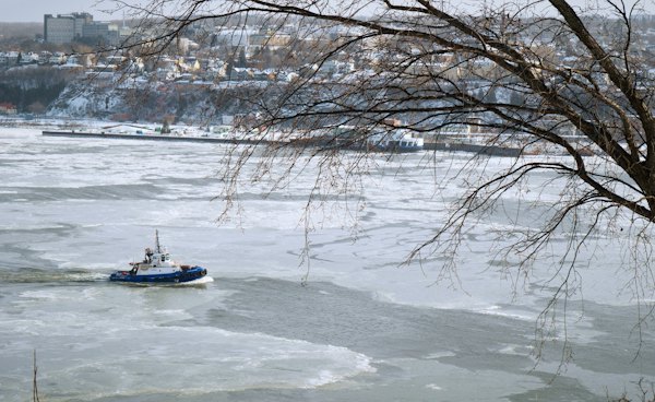A small boat floating on top of a frozen river — Quebec City, Canada