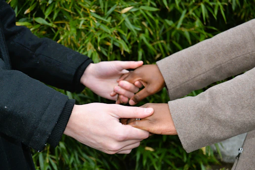 A group of people standing next to each other holding hands