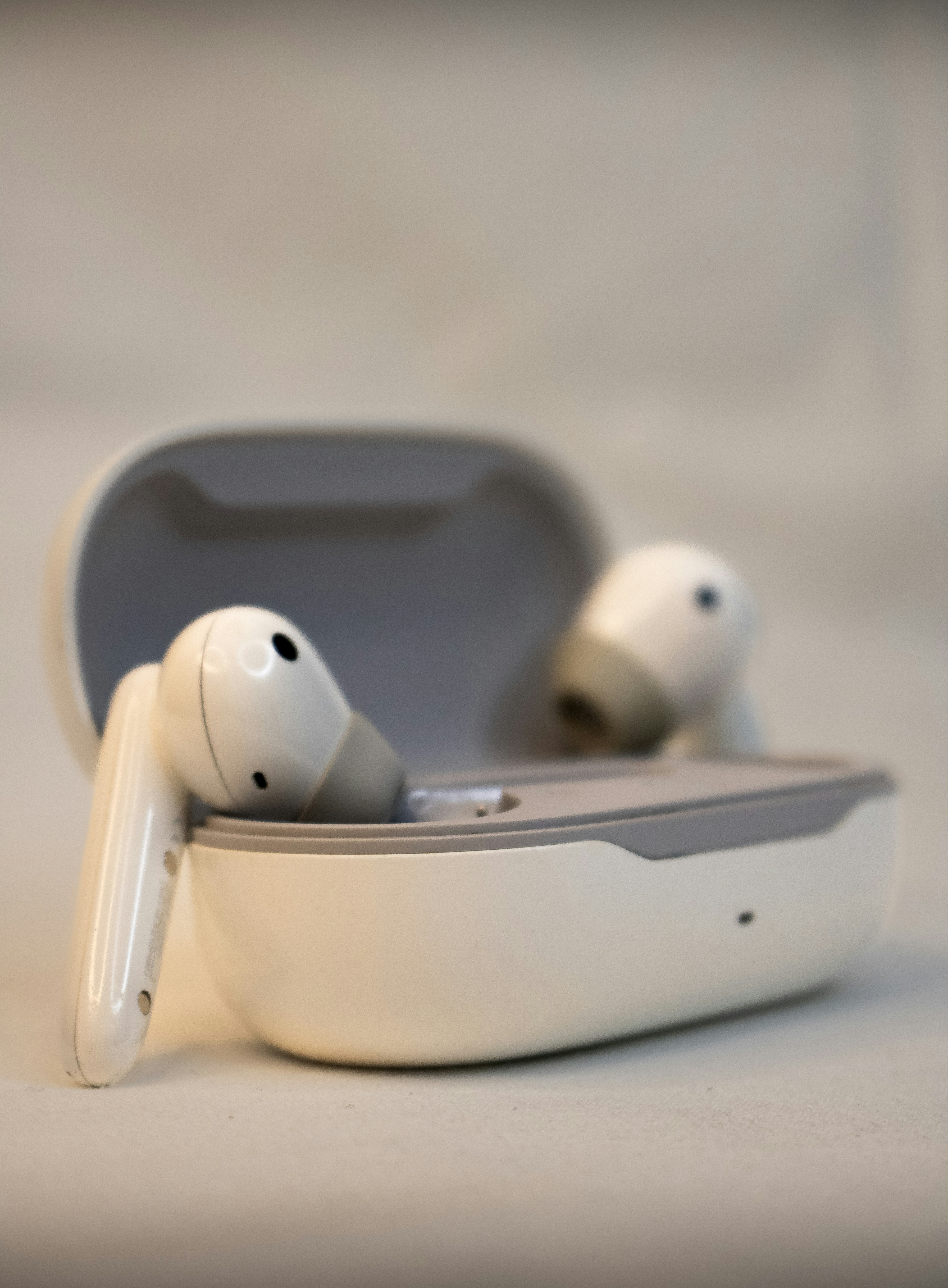 A pair of white earbuds sitting in a case
