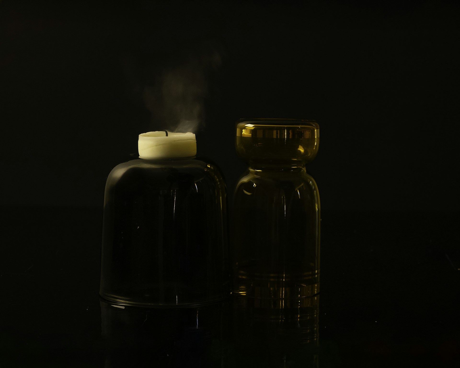 A candle and a bottle on a table